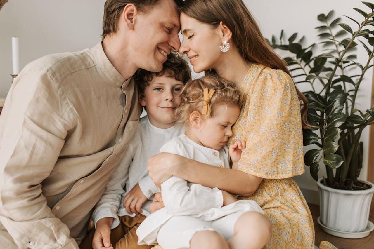 Le_aspettative_per_la_finale_OBcVIJWbUU - Confidenze24 Source: Vlada Karpovich - pexels - A loving family of four shares a tender moment in a cozy indoor setting, embracing and smiling.