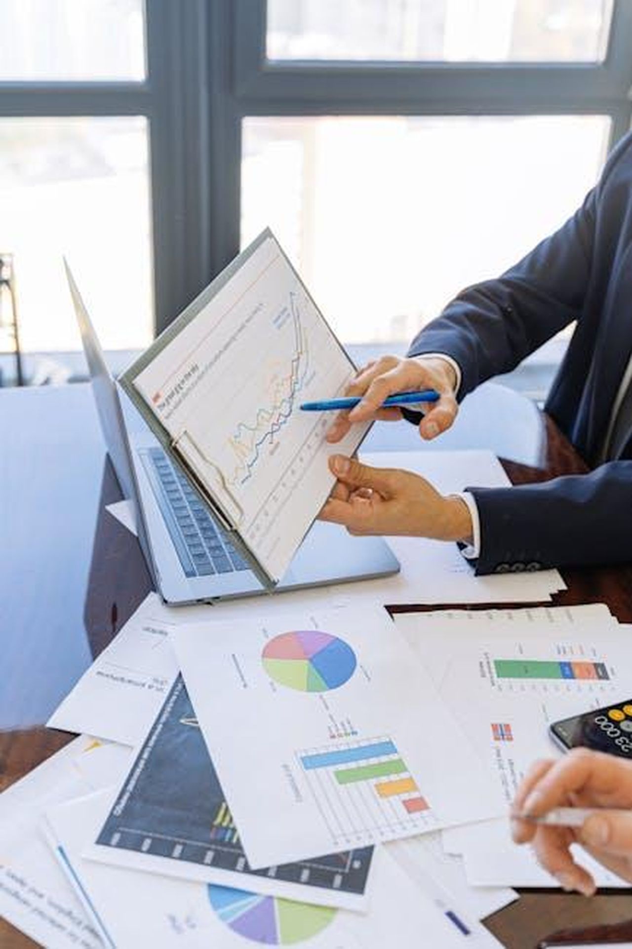 Le_attivit_del_consulente_finanziario_bYZanjK7vf - Confidenze24 Source: Antoni Shkraba - pexels - Business professionals discussing financial graphs and charts in an office setting.