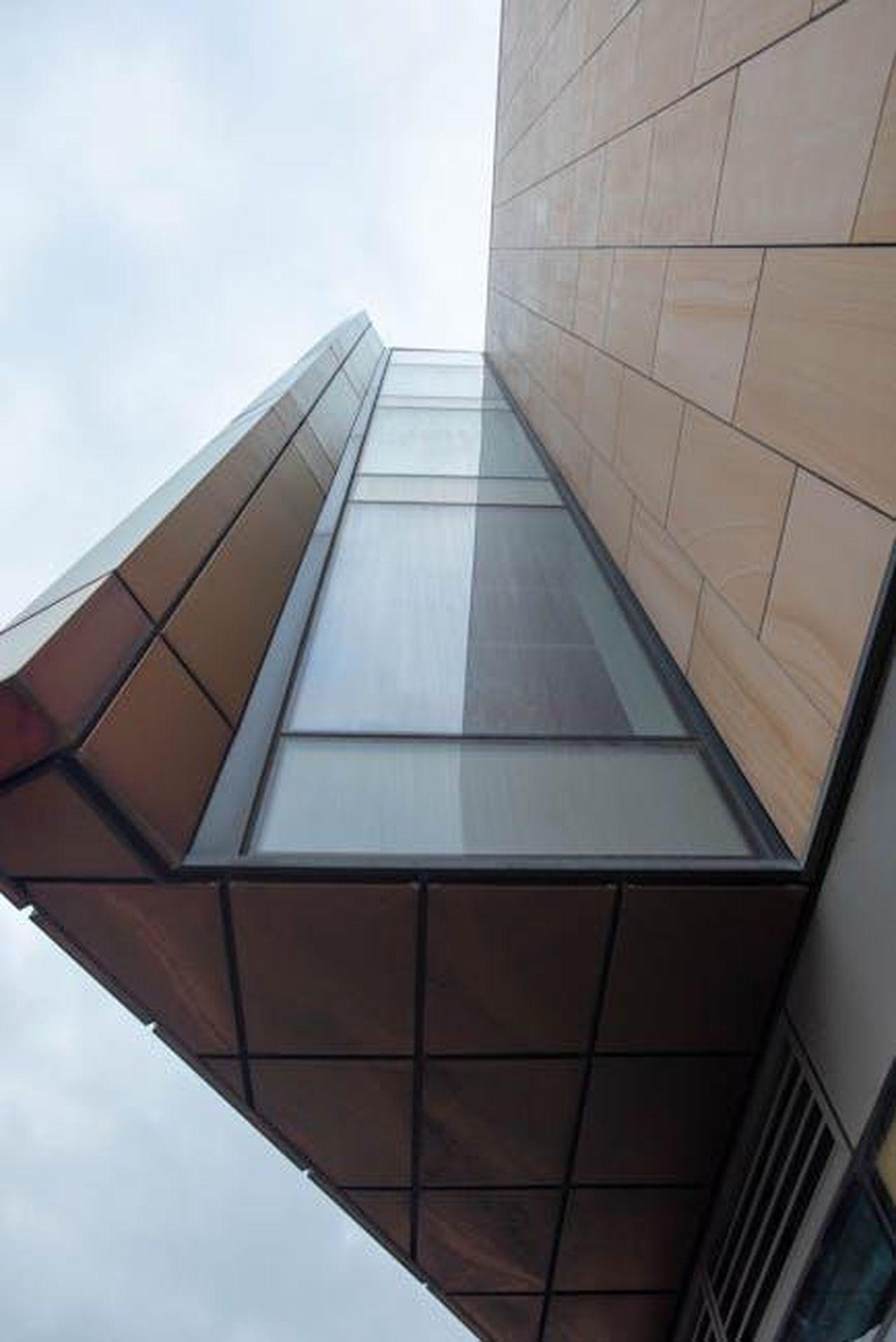 Le_conseguenze_delle_azioni_di_Musk_PQlzxUJSFk - Confidenze24 Source: Damien Wright - pexels - A striking view of contemporary architecture capturing geometric shapes and glass facade from below.