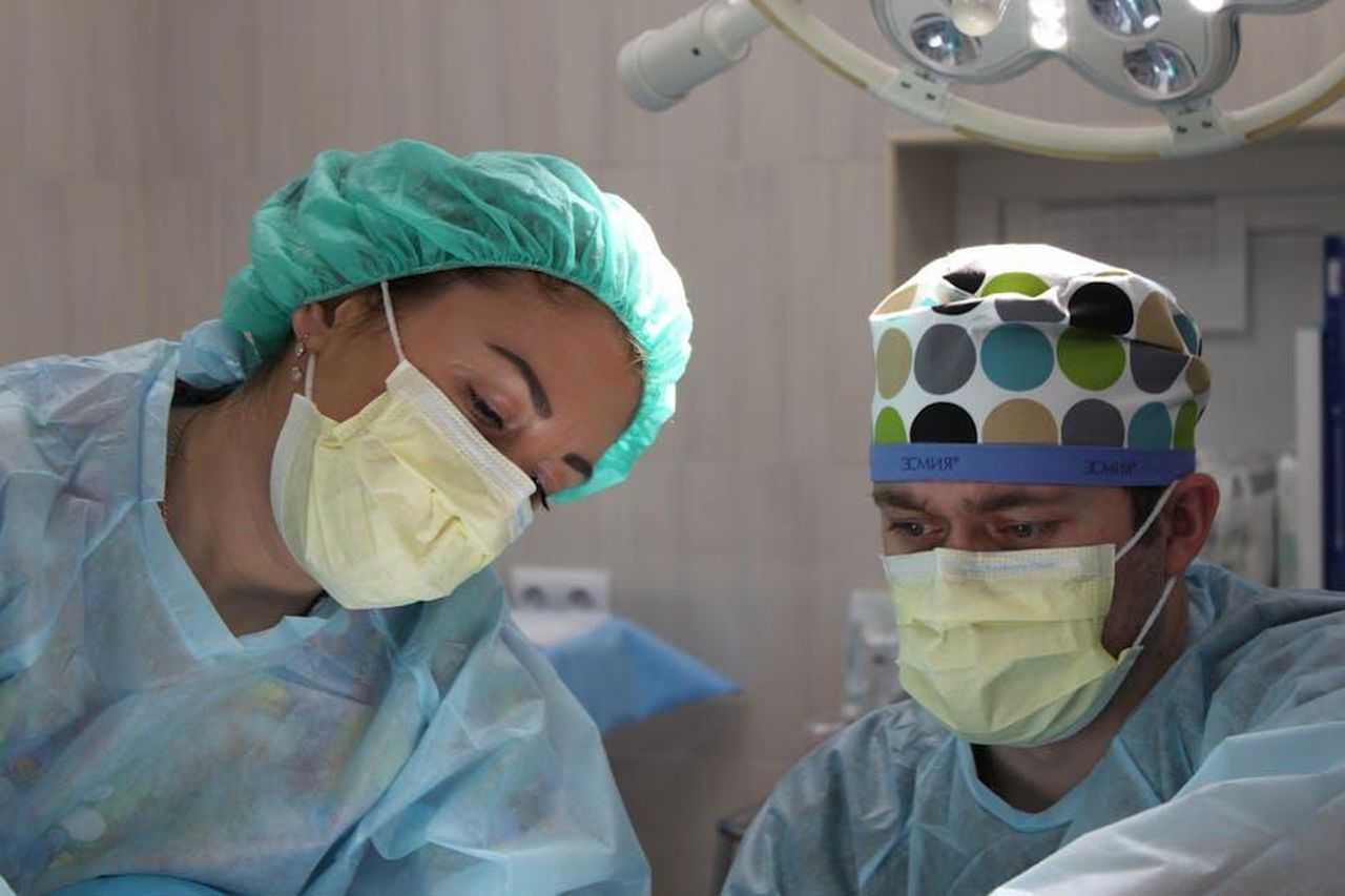 Le_conseguenze_dellintervento_chirurgico_UgkgMleCRD - Confidenze24 Source: Павел Сорокин - pexels - Surgeons wearing masks and scrubs conduct an operation in a hospital setting.