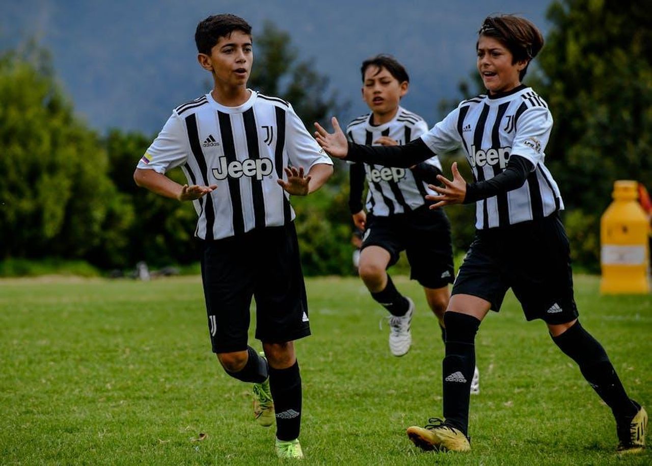 Le_dichiarazioni_di_Nicol_Schira_su_Renato_Veiga_wVdB03A2hg - Confidenze24 Source: Laura Rincón - pexels - Kids enjoying a game of football outdoors in Juventus jerseys, showcasing teamwork and sportsmanship.