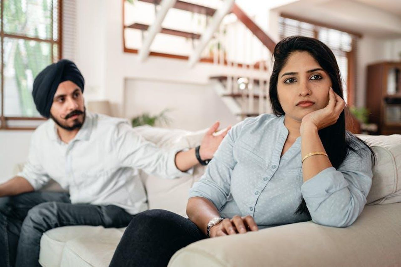 Le_frecciatine_dopo_laereo_iSjgUxq7ZK - Confidenze24 Source: Ketut Subiyanto - pexels - Young bearded Sikh man in casual wear and turban arguing with sad wife sitting on sofa