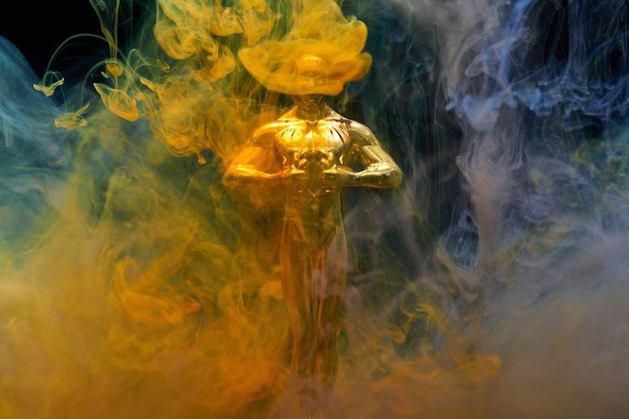 Le_opinioni_dei_votanti_sugli_altri_film_ouhTVBOIzJ - Confidenze24 Source: Engin Akyurt - pexels - A golden statuette enveloped in vibrant yellow and blue smoke, symbolizing achievement and success.