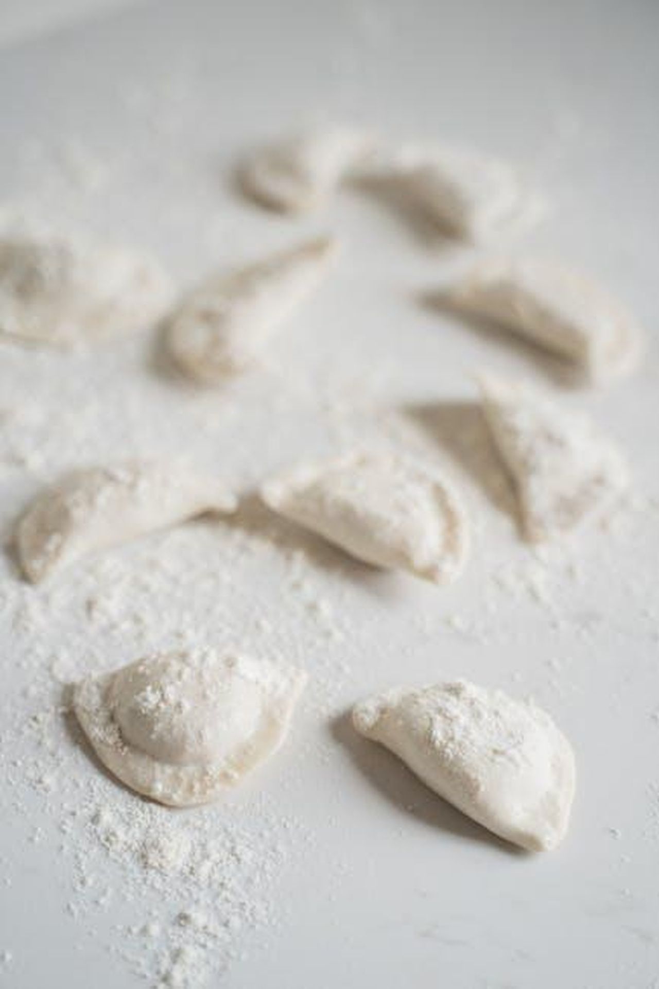 Le_origini_e_il_debutto_di_Marco_Giallini_2rKI4gHyKH - Confidenze24 Source: Anna Tarazevich - pexels - Close-up of uncooked dumplings on a floured surface, showcasing Asian culinary traditions.