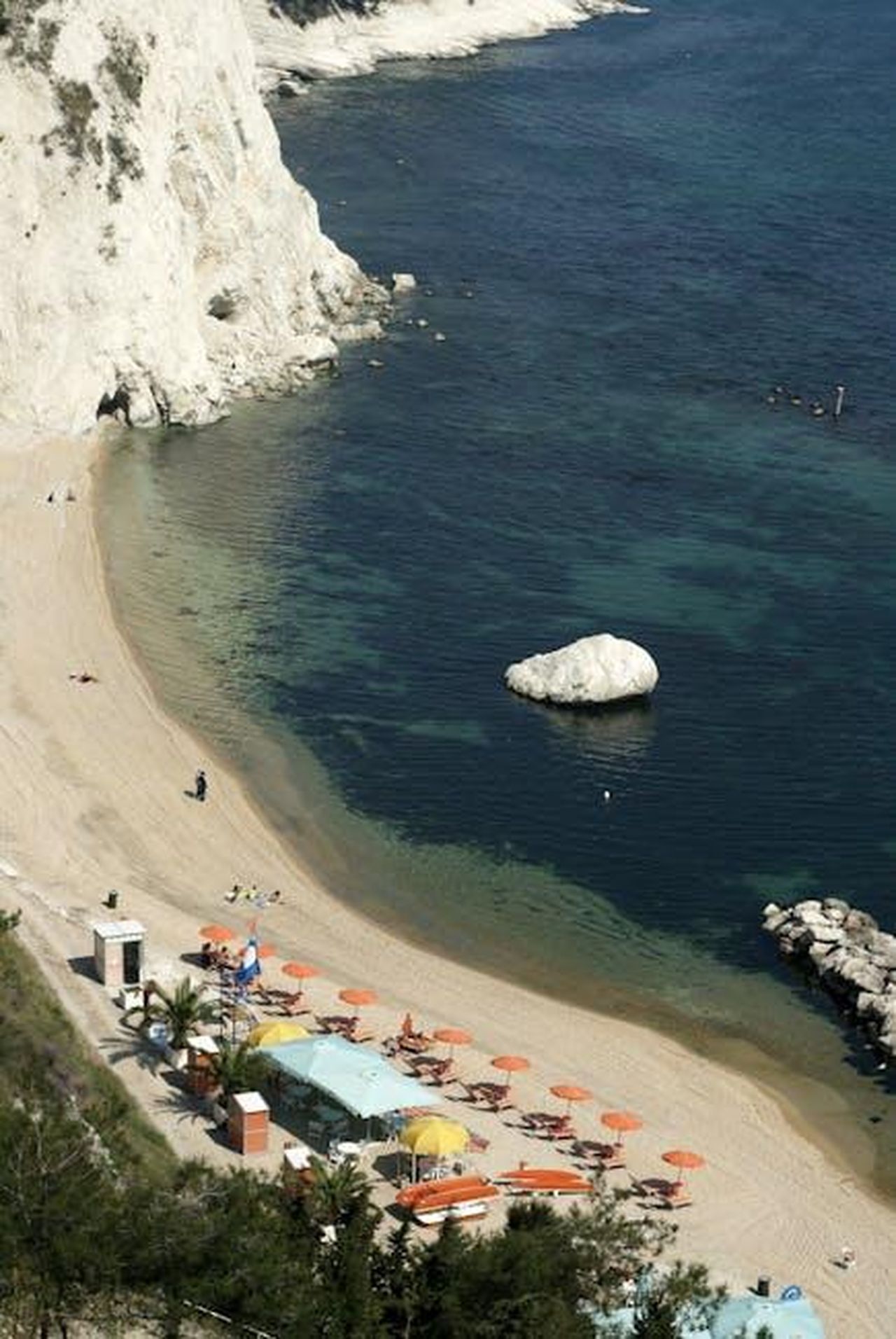 Le_parole_dallesterno_per_gli_zevier_up2Jp001x8 - Confidenze24 Source: Roman Biernacki - pexels - A beautiful beach scene with coastal cliffs and vibrant umbrellas on a sunny day in Italy.