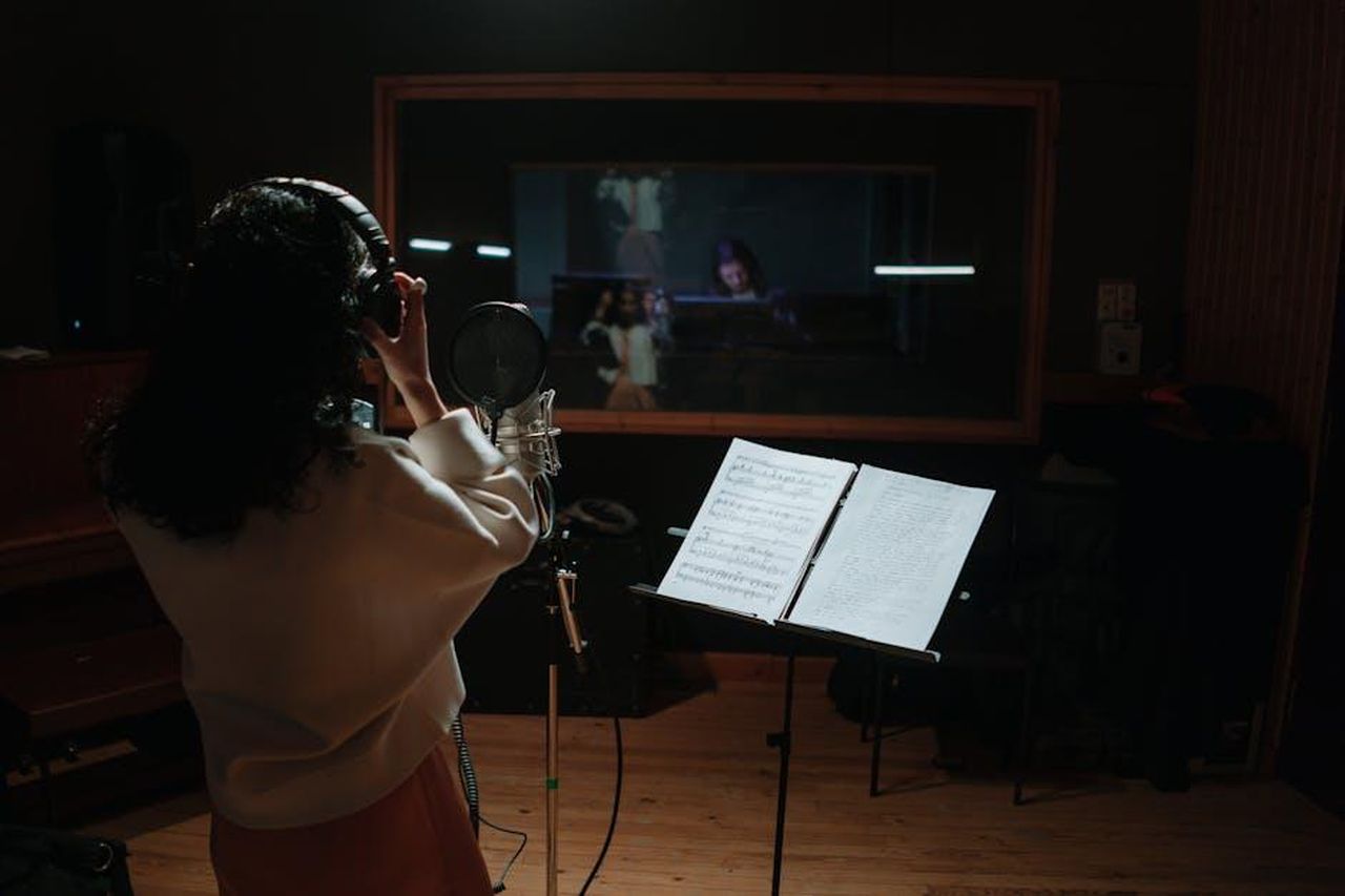 Le_parole_di_Chiara_e_la_canzone_di_Andrea_Laszlo_De_Simone_LZB6Ucrj5O - Confidenze24 Source: cottonbro studio - pexels - A female singer records vocals in a professional music studio with a microphone and sheet music.