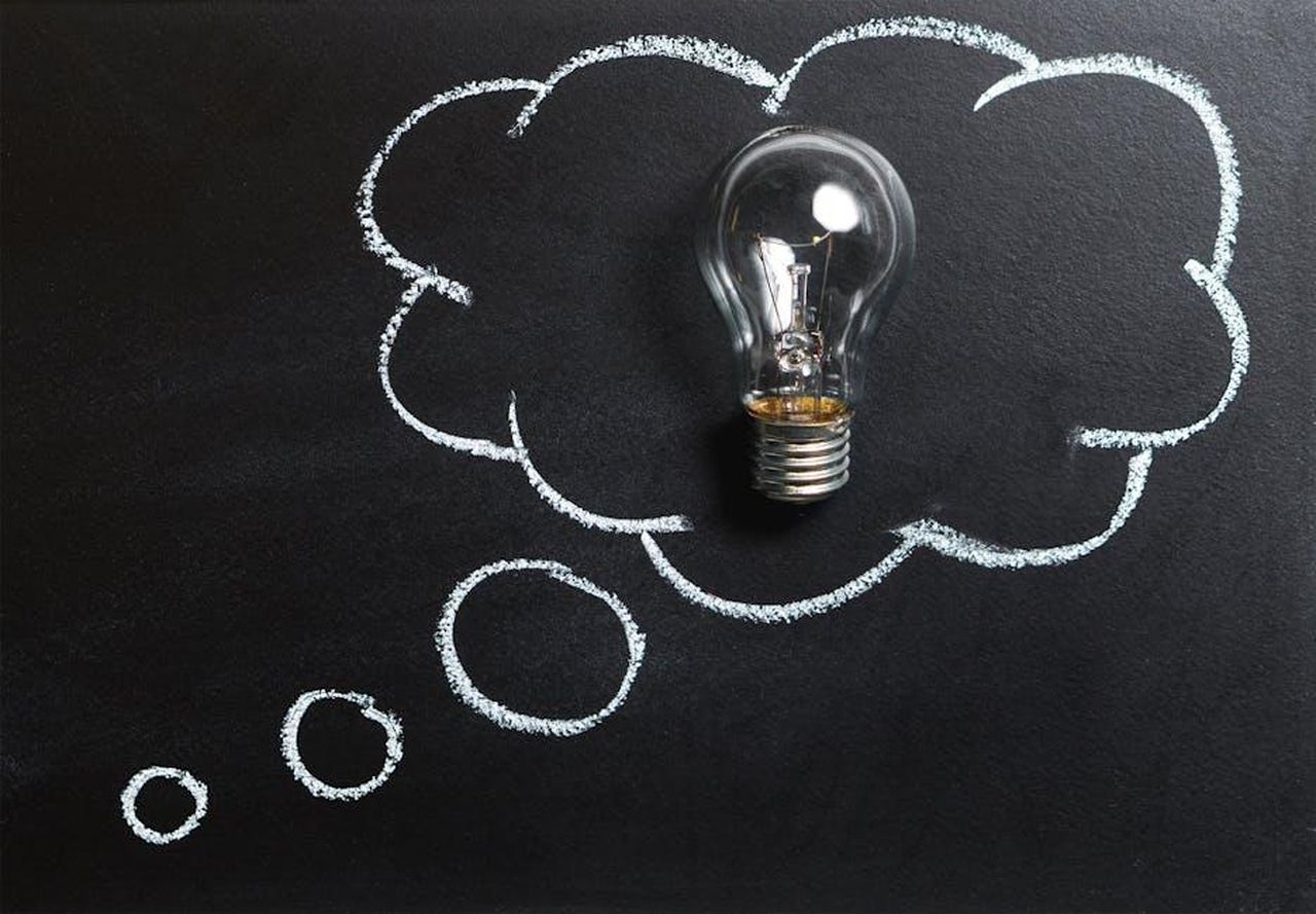 Le_parole_di_Sezai_faranno_pensare_Guzide_RSeurJqMgv - Confidenze24 Source: Pixabay - pexels - Light bulb laying on chalkboard with drawn thought bubble, symbolizing creative ideas.