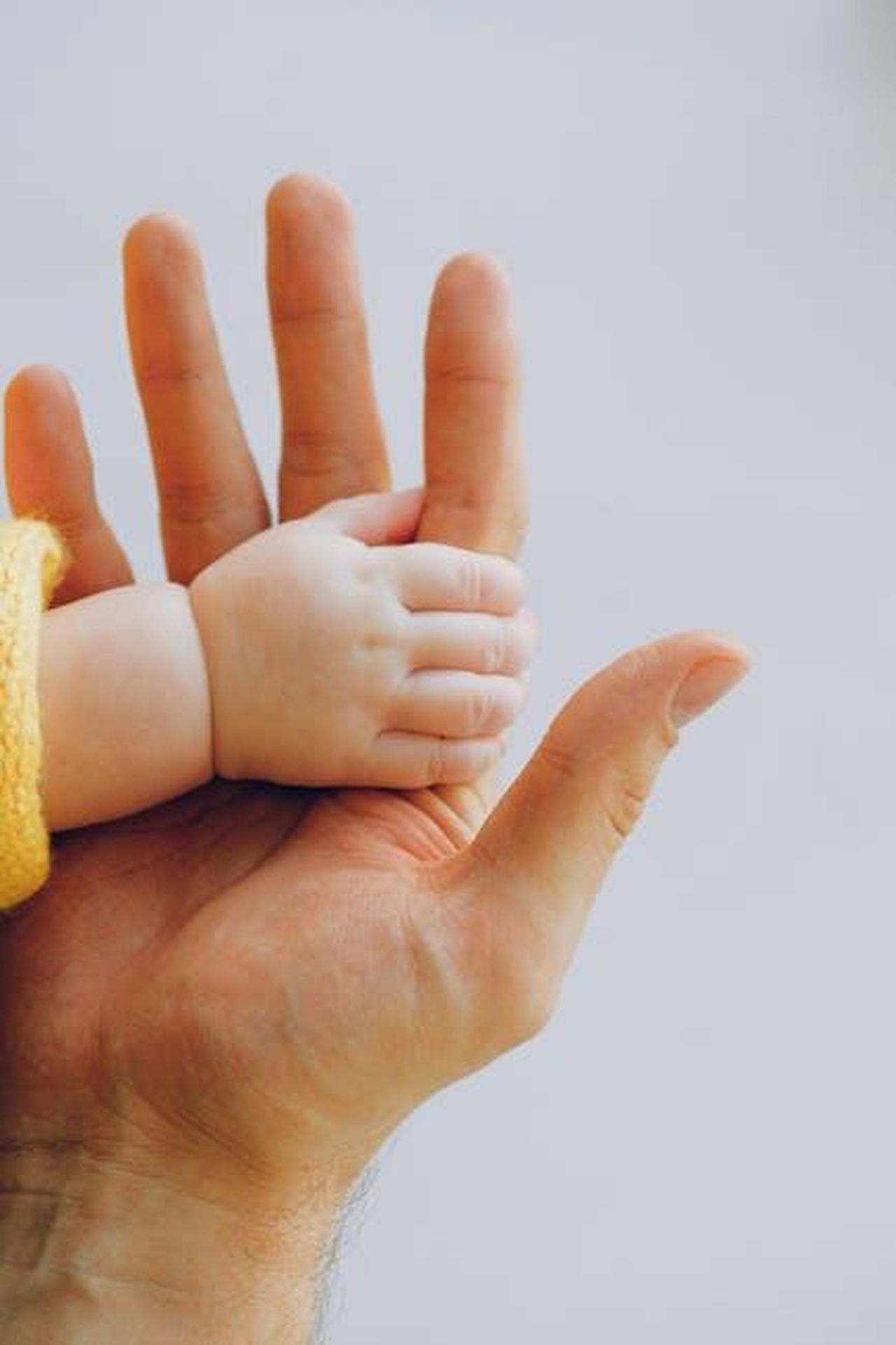 Le_perplessit_di_Javier_cMSVAB3vEy - Confidenze24 Source: Anna Shvets - pexels - Tender moment captured between a baby and parent's hands symbolizing love and trust.