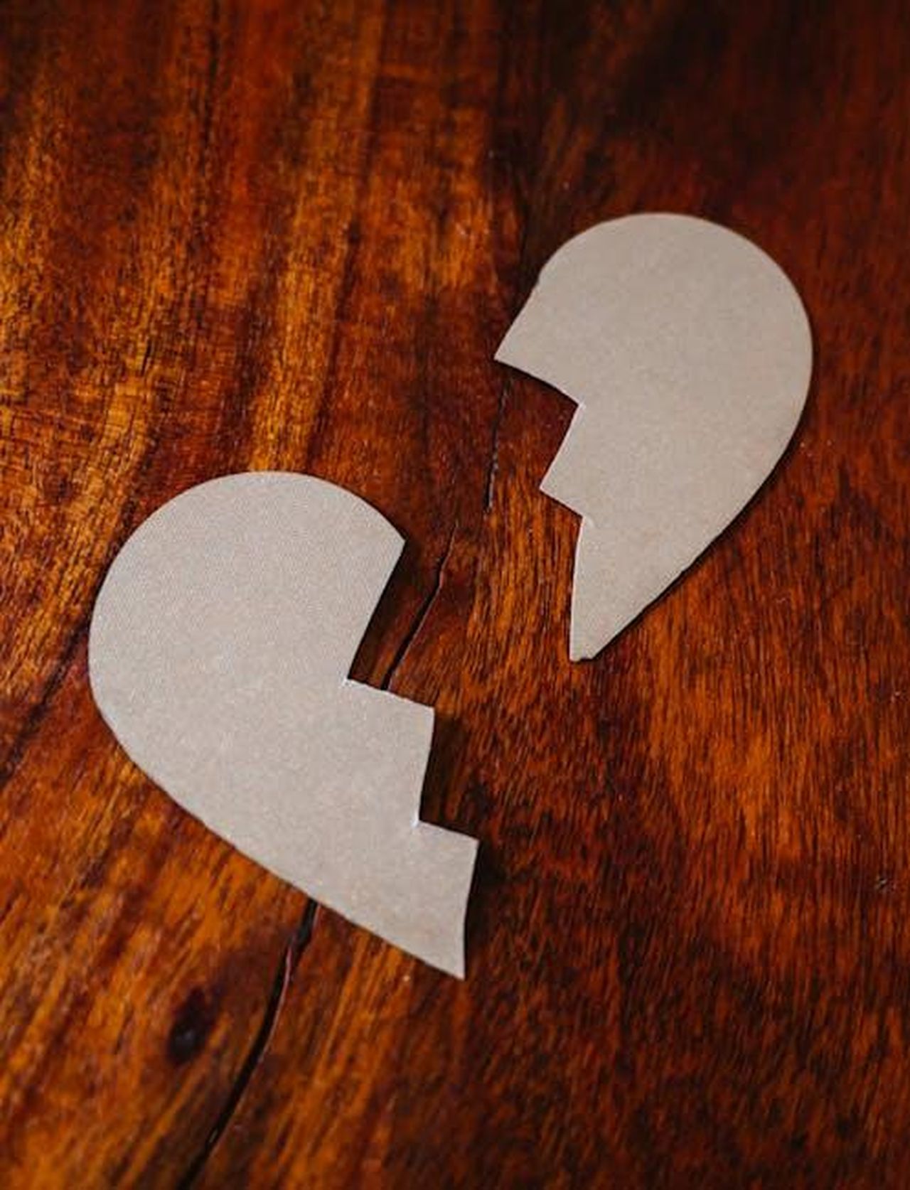 Le_preoccupazioni_di_Mariavittoria_1lpQZuY0Gv - Confidenze24 Source: RDNE Stock project - pexels - Cardboard broken heart symbol on wooden table, representing love and separation.