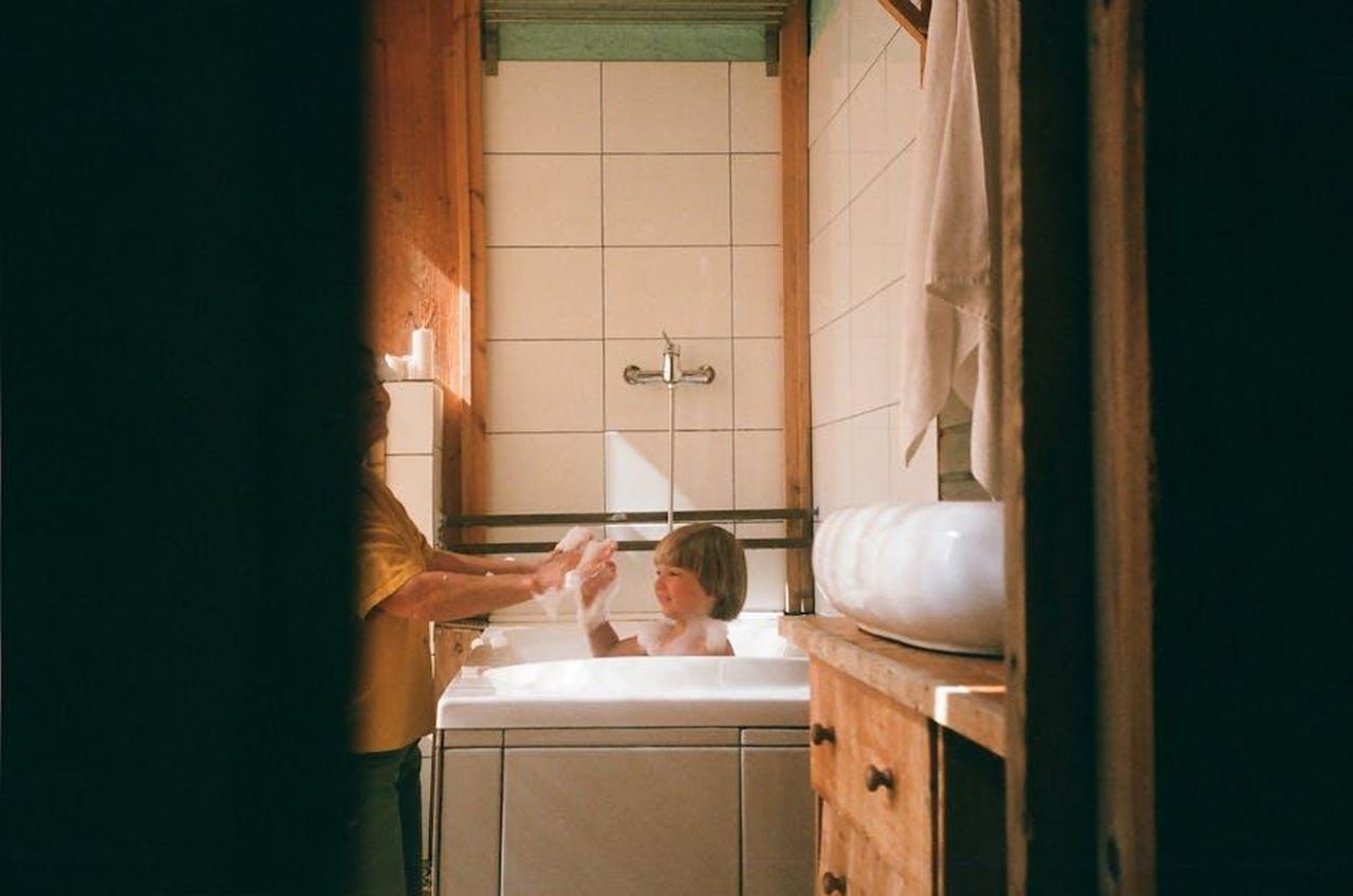Le_prossime_sfide_della_Juventus_9LM9TQj34I - Confidenze24 Source: cottonbro studio - pexels - A child enjoys bath time with a parent in a warm, cozy wooden bathroom setting.