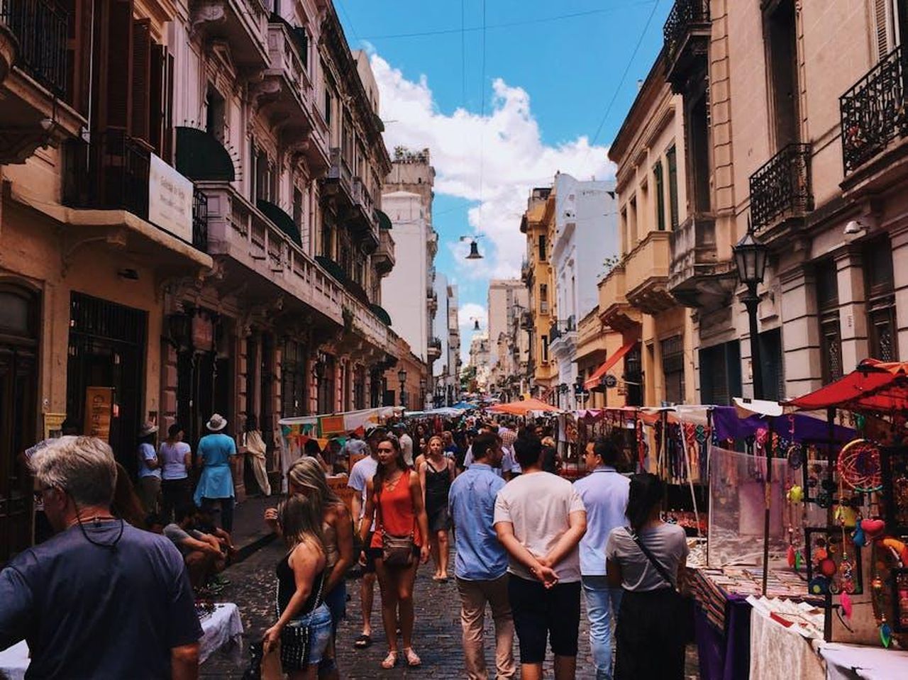 Le_riprese_si_spostano_a_Buenos_Aires_wv3K4E18bf - Confidenze24 Source: Rafael Guimarães - pexels - Bustling San Nicolas street market in Buenos Aires with stalls and crowds under a clear sky.