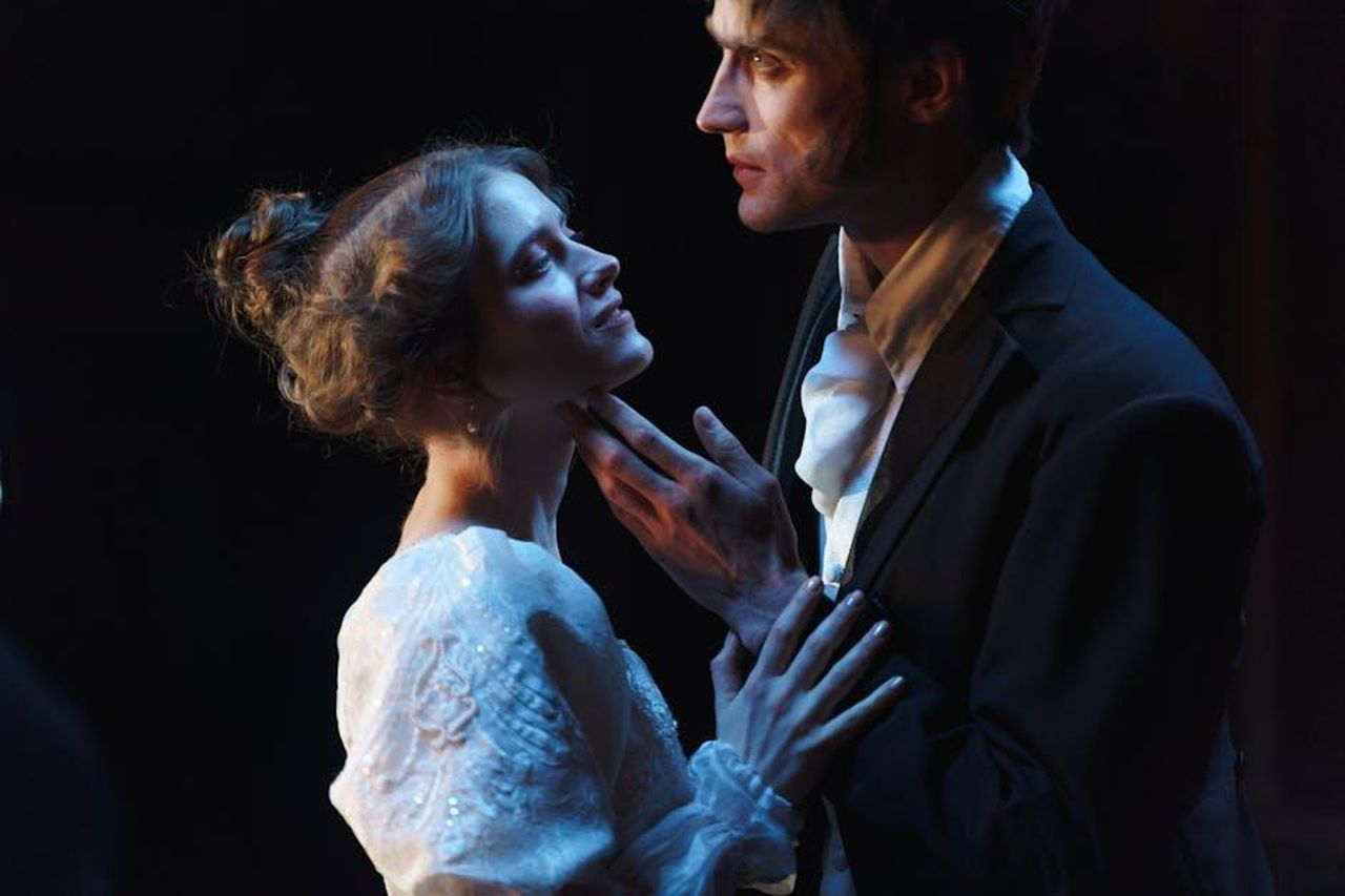 Leander_si_avvicina_a_Jasmin_YVUUBz6wf6 - Confidenze24 Source: cottonbro studio - pexels - A romantic moment between a couple on stage, set against a theatrical backdrop.
