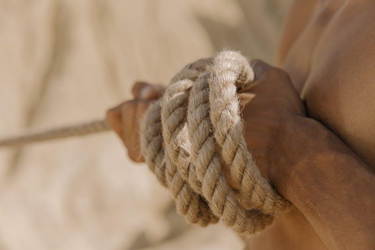 Legame_familiare_oeL6oAnamW - Confidenze24 Source: cottonbro studio - pexels - A close-up view of a person's hands tightly gripping a rope during a tug-of-war competition outdoors.