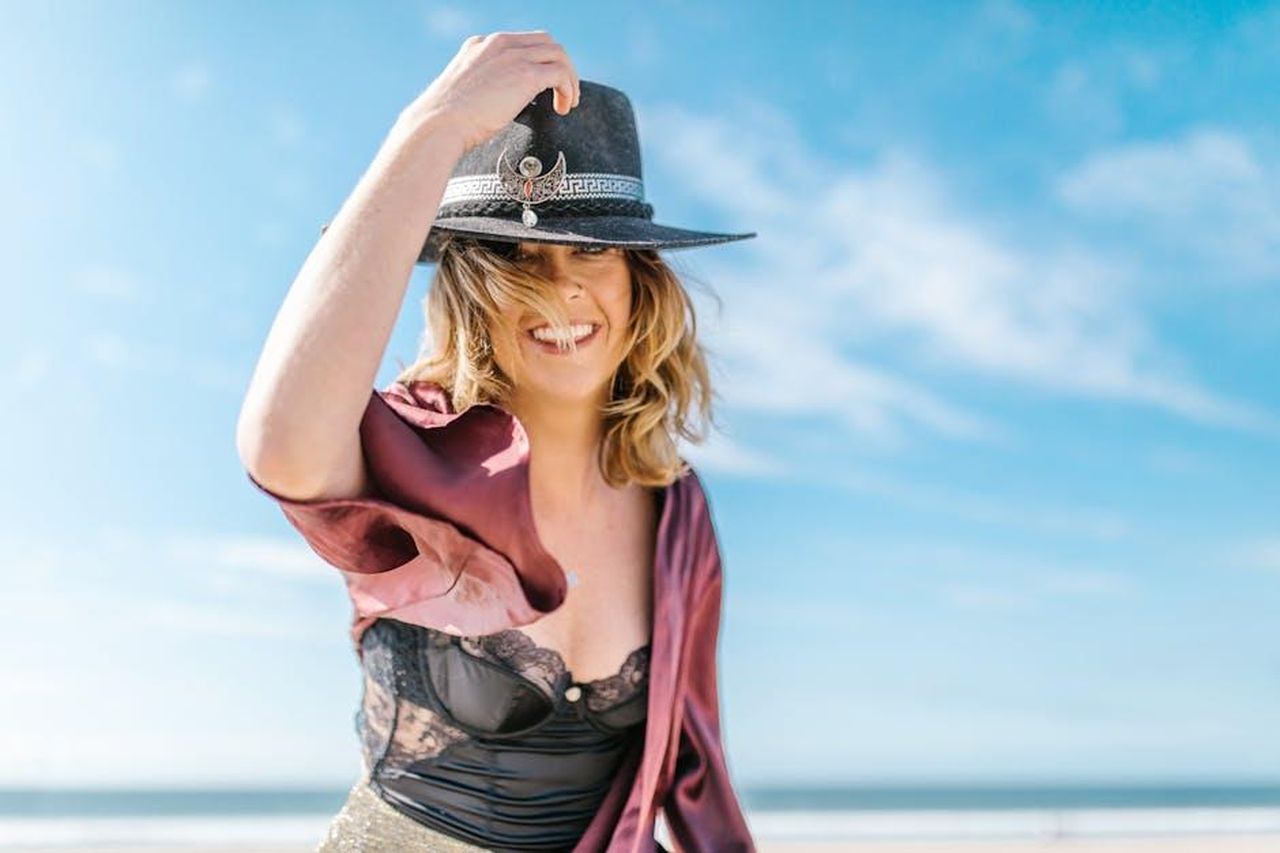 Leone_23_luglio__22_agosto_dSJWyRPAZ1 - Confidenze24 Source: RDNE Stock project - pexels - Cheerful woman in stylish outfit posing on a sunny beach, exuding happiness and freedom.