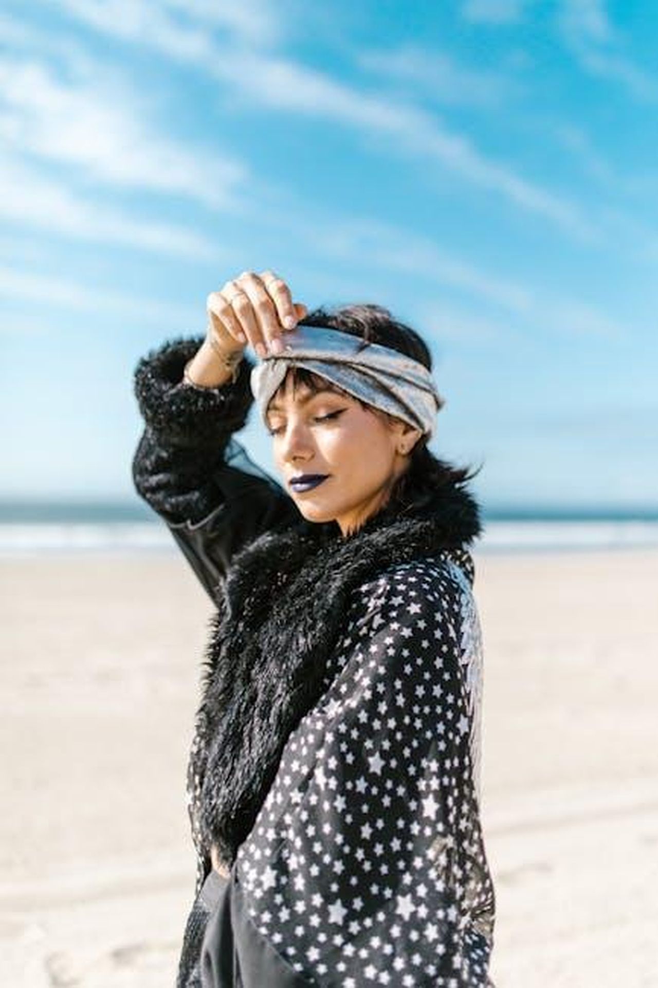 Leone_emozioni_forti_qcsAKhyzNo - Confidenze24 Source: RDNE Stock project - pexels - A stylish woman in bohemian attire soaks up the sun on a serene beach.