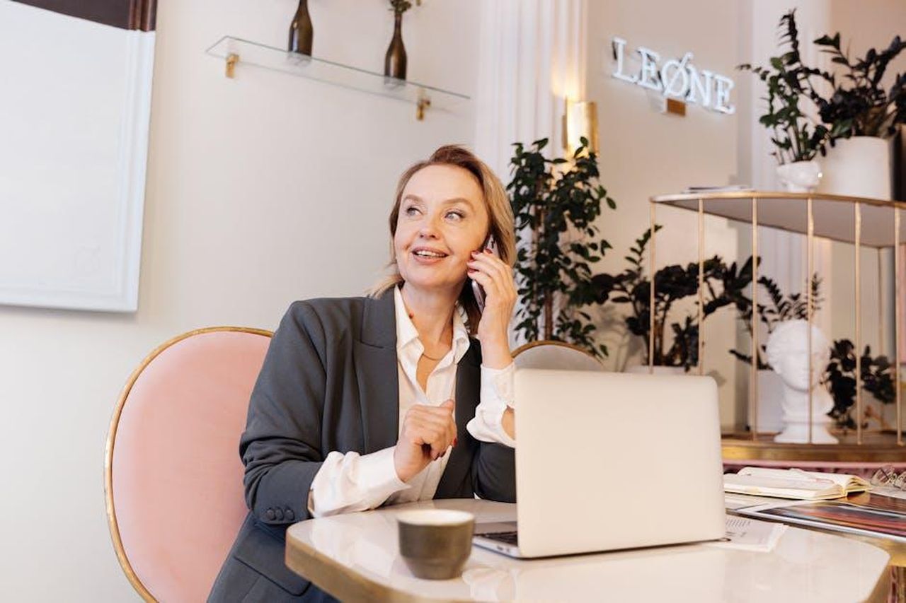 Leone_relazioni_illuminate_da_Venere_WpYUb7ADYW - Confidenze24 Source: Antoni Shkraba - pexels - Businesswoman in office, speaking on phone, smiling, with laptop.