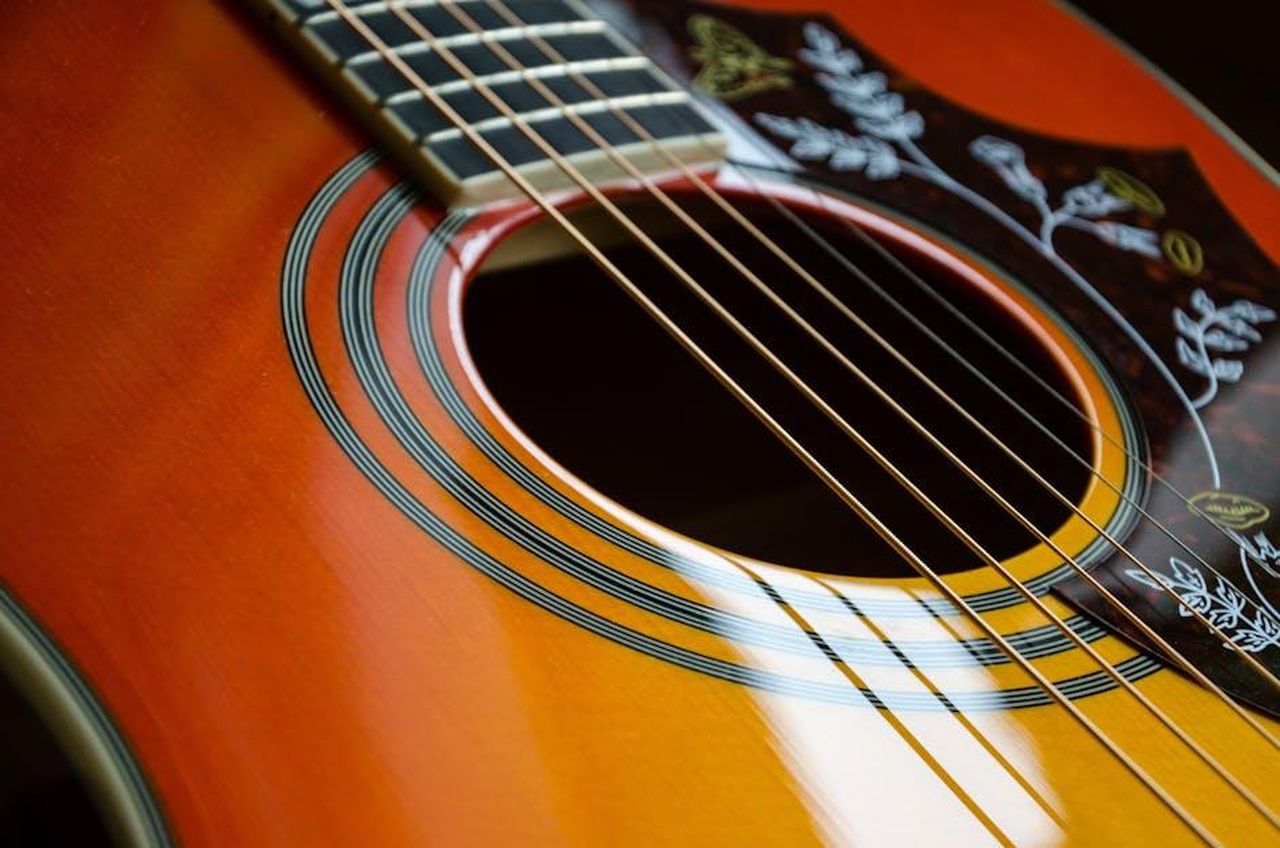 Leredit_di_Roberta_Flack_nella_musica_HS983ACDIr - Confidenze24 Source: Pixabay - pexels - Detailed view of an acoustic guitar's strings and sound hole with intricate design.