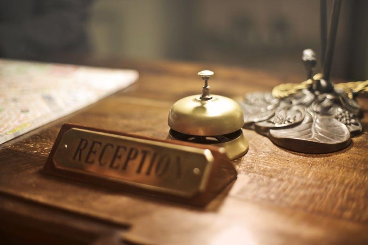 Lezioni_di_ospitalit_da_Meghan_jgw45Q42De - Confidenze24 Source: Andrea Piacquadio - pexels - Old fashioned golden service bell and reception sign placed on wooden counter of hotel with retro interior