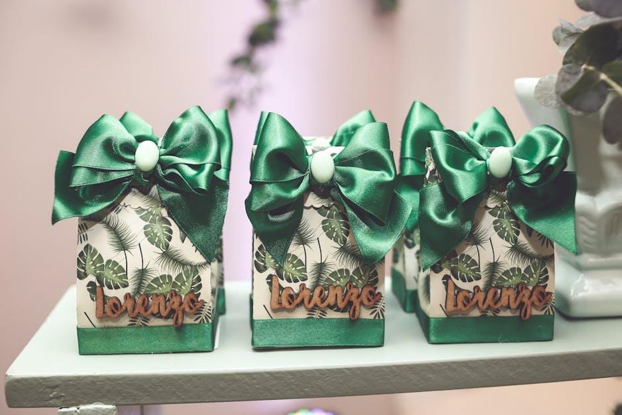 Lorenzo_Spolverato_attacca_Helena_Non_le_frega_di_niente_e_di_nessuno_FxpOqLm9mW - Confidenze24 Source: Vidal Balielo Jr. - pexels - Set of decorated gift boxes with green bows and tropical leaf pattern, labeled 'Lorenzo'.