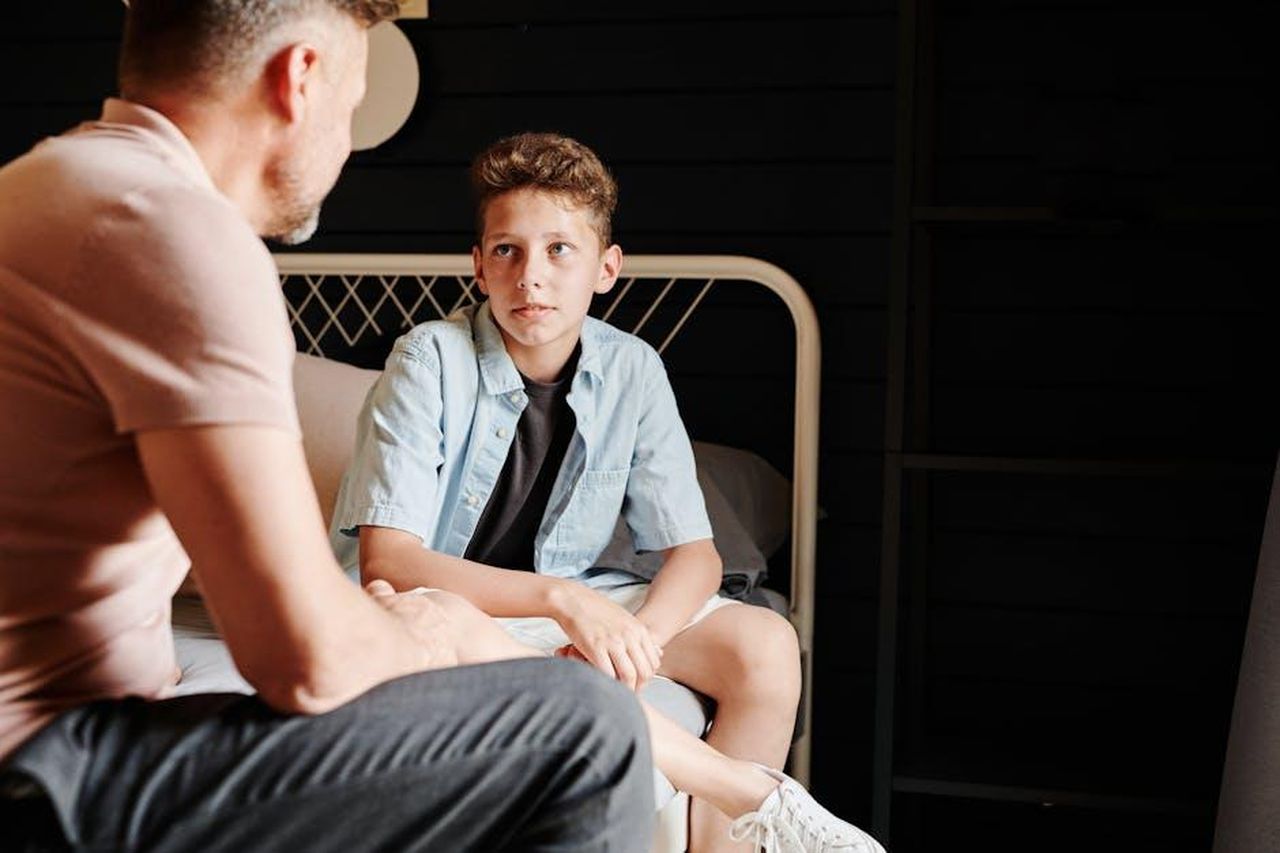 Lorenzo_mette_in_guardia_Shaila_Prima_di_parlare_pensa_LuFVQRm45R - Confidenze24 Source: Julia M Cameron - pexels - A father and son share a heartfelt conversation indoors, capturing a moment of bonding.