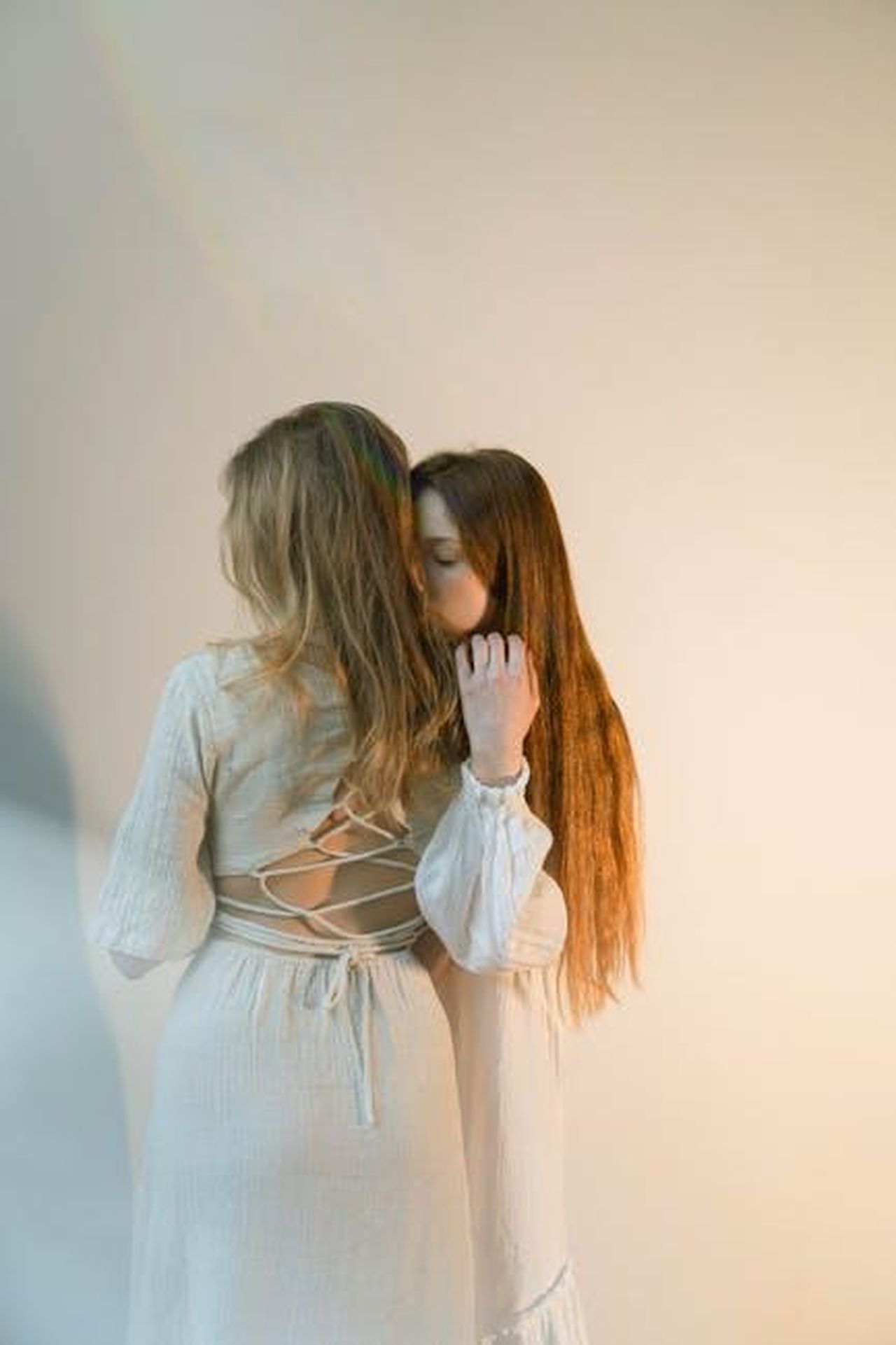 Loroscopo_dellamore_di_marzo_un_viaggio_astrologico_tra_passioni_incontri_e_destini_intrecciati_Erxd8Unnij - Confidenze24 Source: Anastasia Shuraeva - pexels - Two women in light dresses embrace gently, creating a serene and intimate moment.