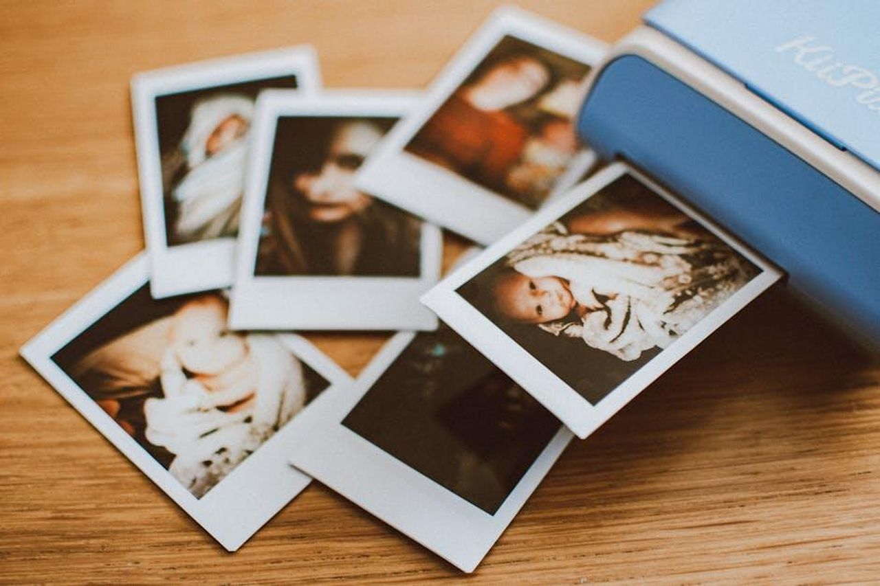 Lucy_Mecklenburgh_scoppia_in_lacrime_INMQNaLKhJ - Confidenze24 Source: Lisa Fotios - pexels - A collection of instant photo prints scattered on a wooden table, featuring personal moments.