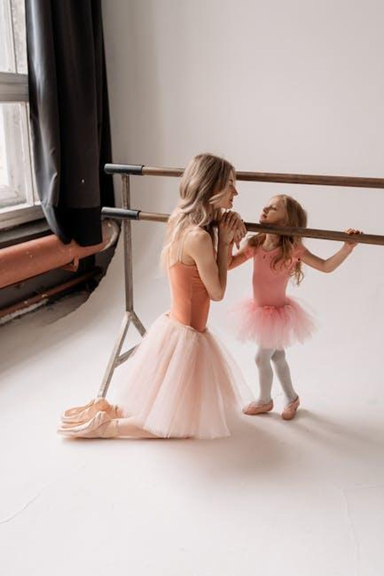 Megan_Ria_e_Gianmarco_Petrelli_una_storia_damore_nIUAYb1dA0 - Confidenze24 Source: Victoria Strelka_ph - pexels - A mother and daughter practicing ballet together indoors, sharing a tender moment in a dance studio.