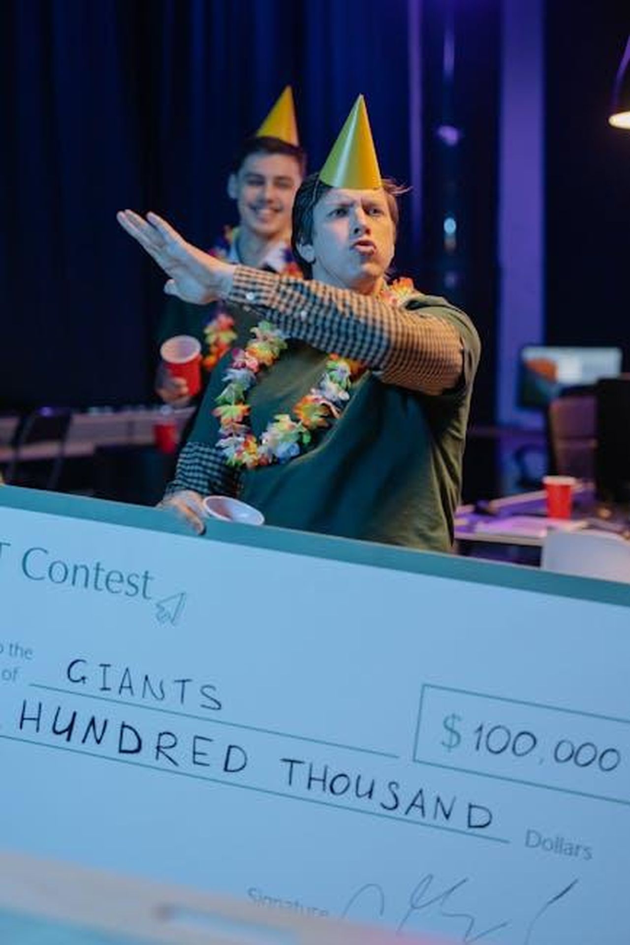 Migliori_vestiti_agli_Spirit_Awards_vLqylgpRNO - Confidenze24 Source: cottonbro studio - pexels - Two men celebrating a contest win with a giant check indoors.