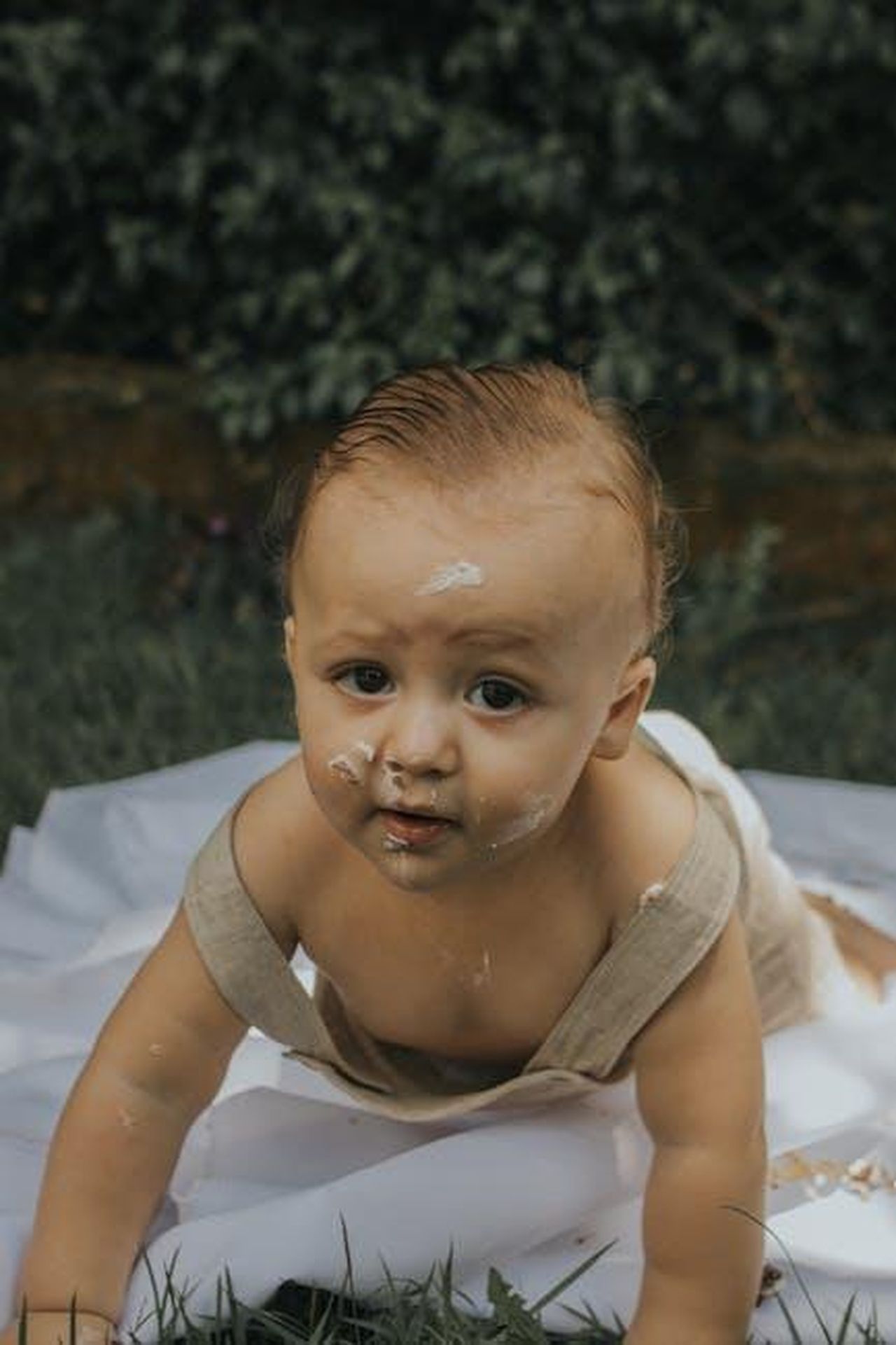 Momenti_in_giardino_con_Meghan_e_i_bambini_1jSVUqPEXX - Confidenze24 Source: juliane Monari - pexels - Cute baby covered in cake frosting crawling on a blanket outdoors.