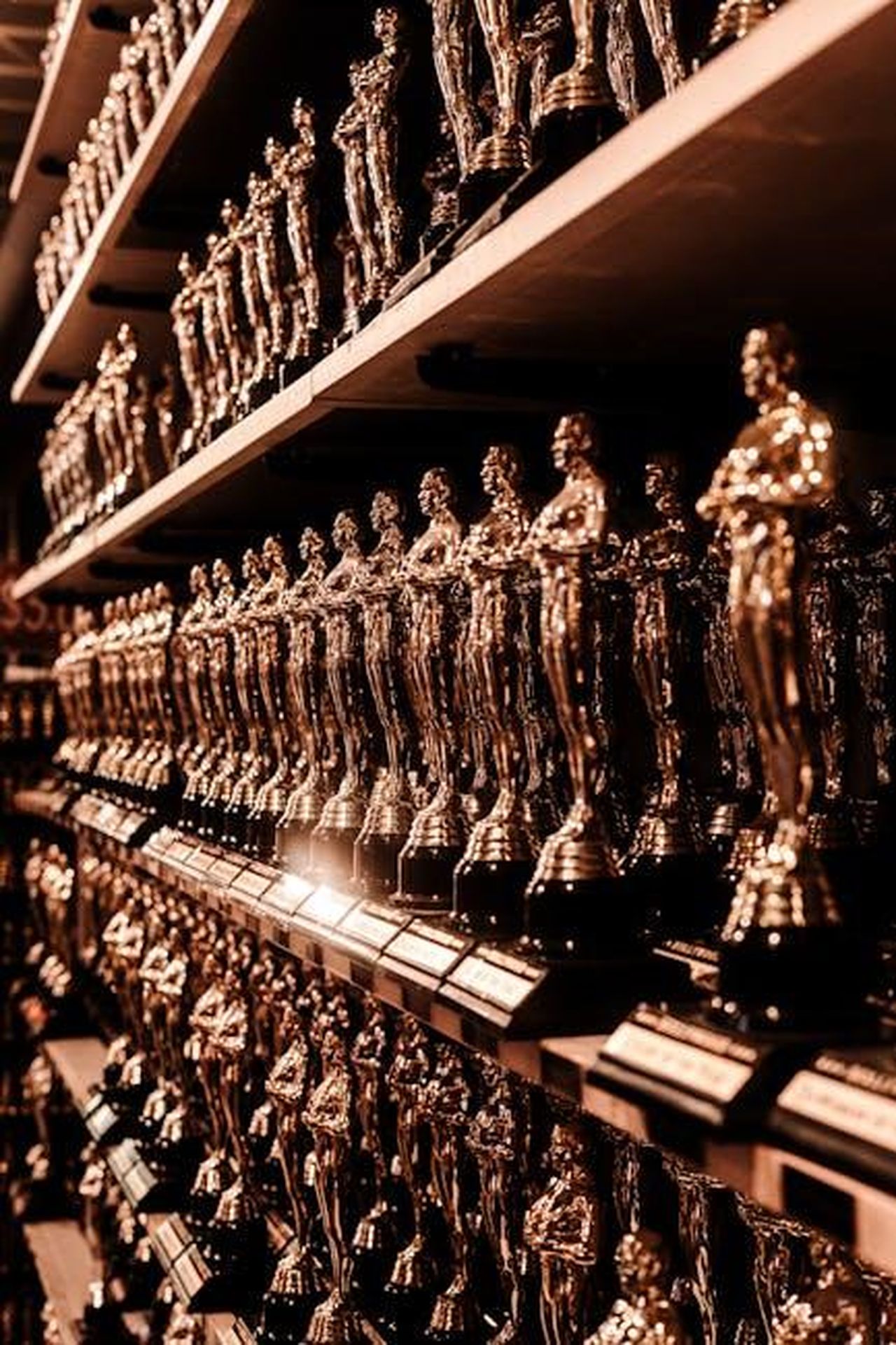 Momenti_salienti_della_serata_sNRf52y0ac - Confidenze24 Source: Nikita Grishin - pexels - Close-up image of numerous golden trophy awards neatly arranged on shelves.