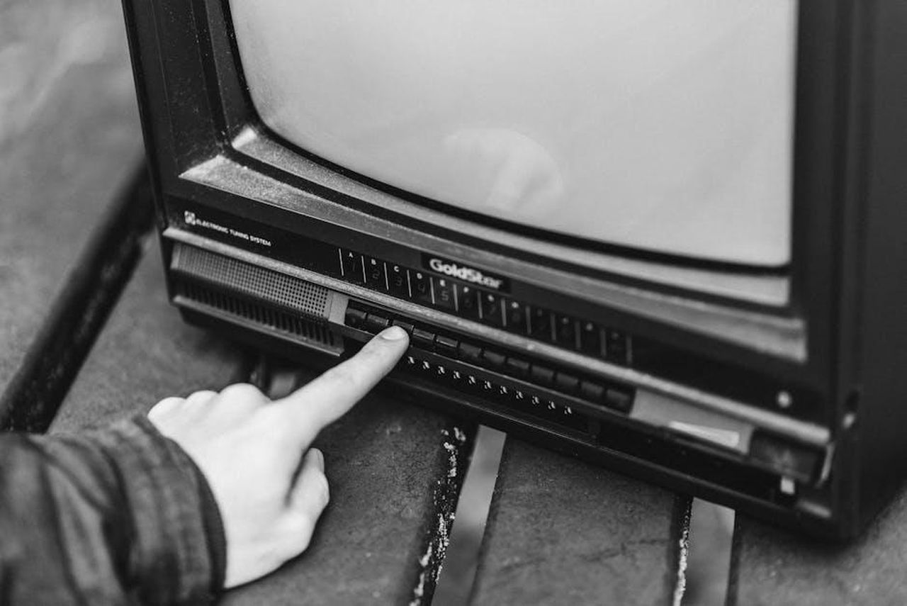 Nelle_puntate_precedenti_4ezj32TikS - Confidenze24 Source: Anete Lusina - pexels - Black and white from above of anonymous male switching channels on retro black television placed in wooden table on street