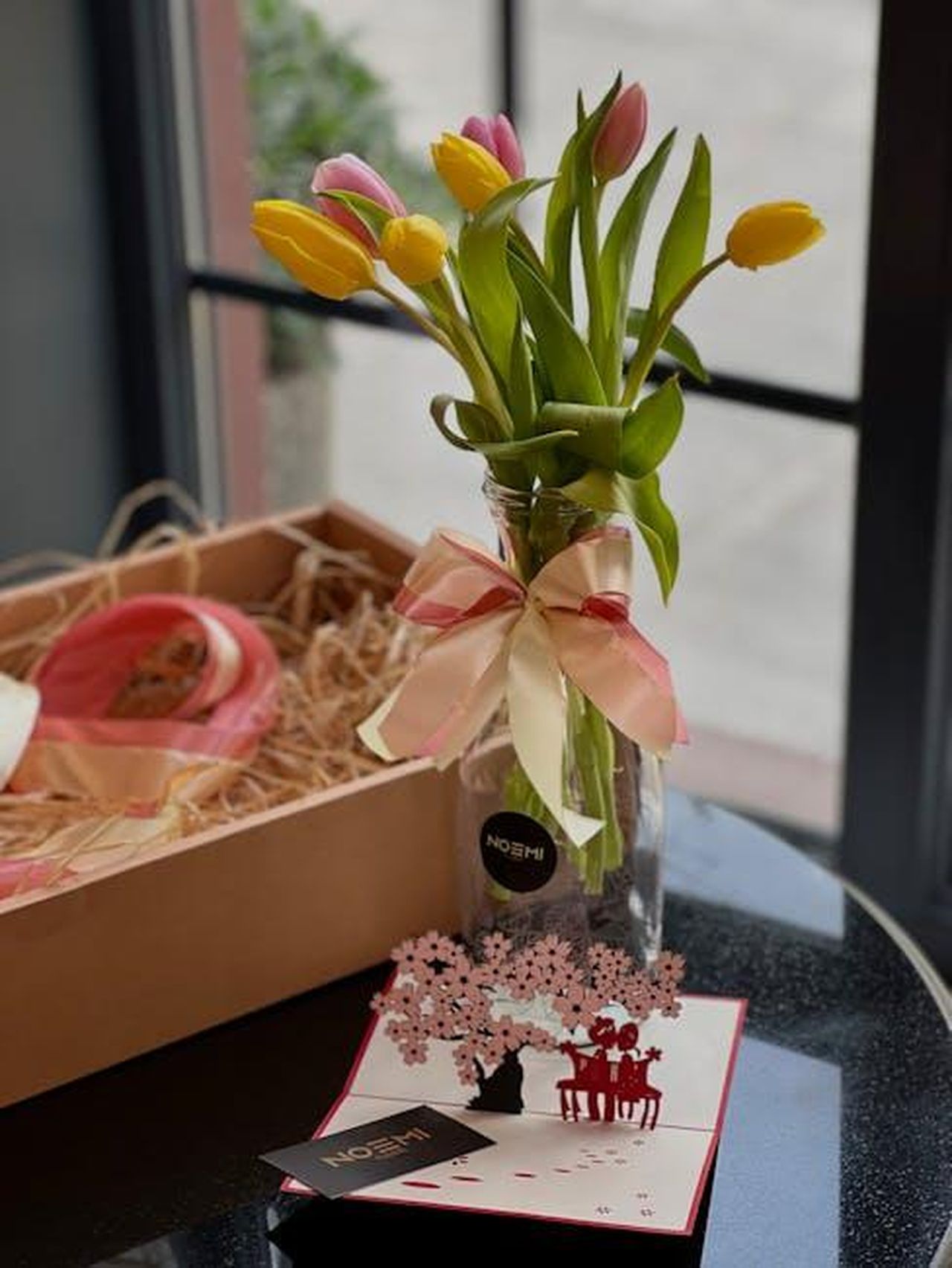 Noemi_e_Tony_Effe__Tutto_il_resto__noia_Franco_Califano_oFcCe6RJnW - Confidenze24 Source: Xatiwikkk - pexels - Vibrant tulips in a glass vase tied with ribbon near a gift box, perfect for decor.
