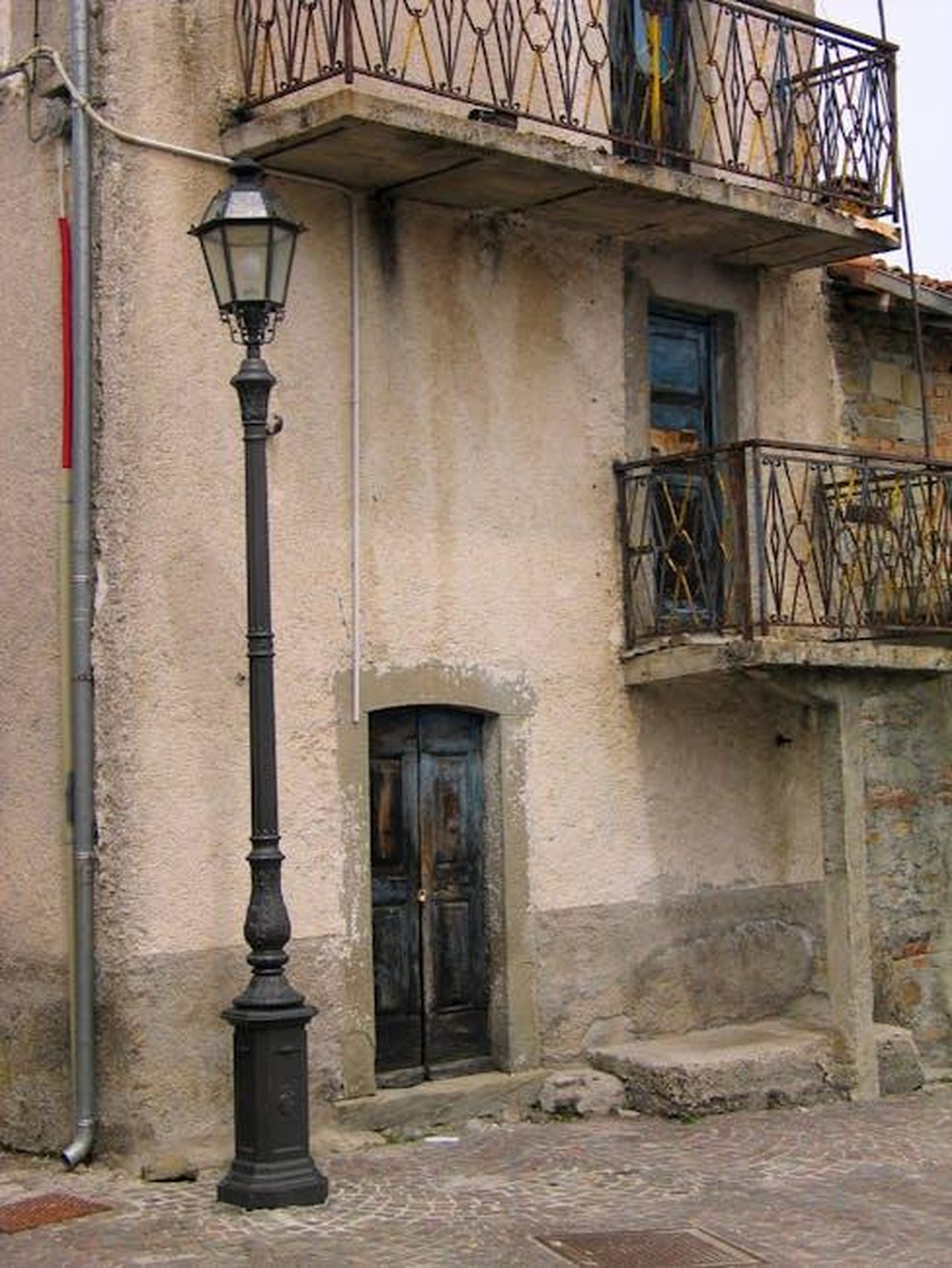 Nomination_e_tensioni_scoppia_il_caos_nella_Casa_O4msYOAvB5 - Confidenze24 Source: Roman Biernacki - pexels - Old European building featuring rustic balconies and a vintage streetlamp in a quaint town.