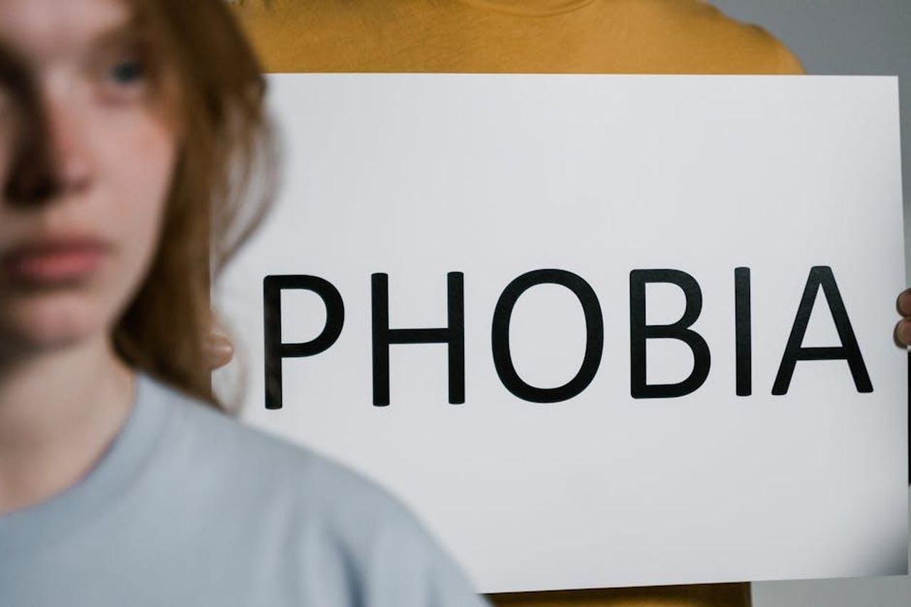 Odile_in_ansia_per_sua_mamma_anticipazioni_Il_Paradiso_delle_signore_2428_febbraio_y1rQywS3If - Confidenze24 Source: MART PRODUCTION - pexels - A close-up of a person holding a sign with the word 'Phobia,' illustrating mental health themes.