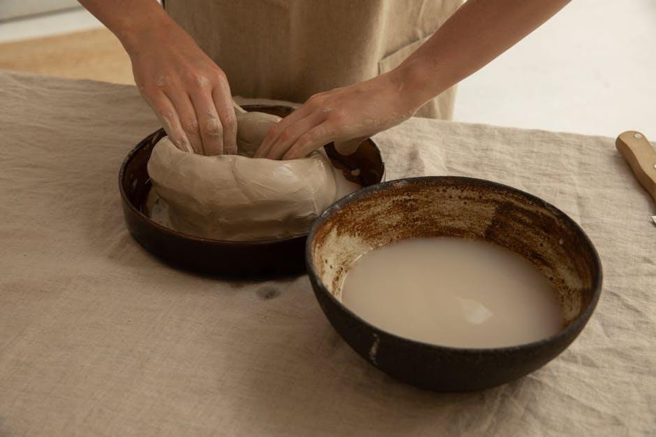 Olympia_aiuta_Serena_per_il_Super_Bowl_dRI4ELtrSC - Confidenze24 Source: Monstera Production - pexels - From above of crop anonymous artisan sculpting soft clay near bowl with liquid on table in workroom