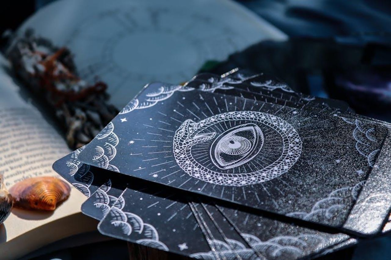 Oroscopo_Paolo_Fox_Leone_TWW3x7JXPX - Confidenze24 Source: dilara irem - pexels - A captivating close-up of tarot cards beside an open book, embodying the mystery of fortune telling.