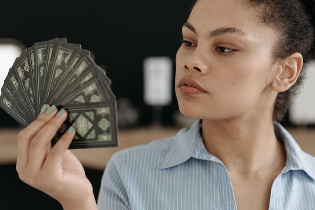 Oroscopo_da_Ariete_a_Cancro_vRmefFzmJe - Confidenze24 Source: Pavel Danilyuk - pexels - Focused young woman examining a fan of tarot cards, exploring divination.