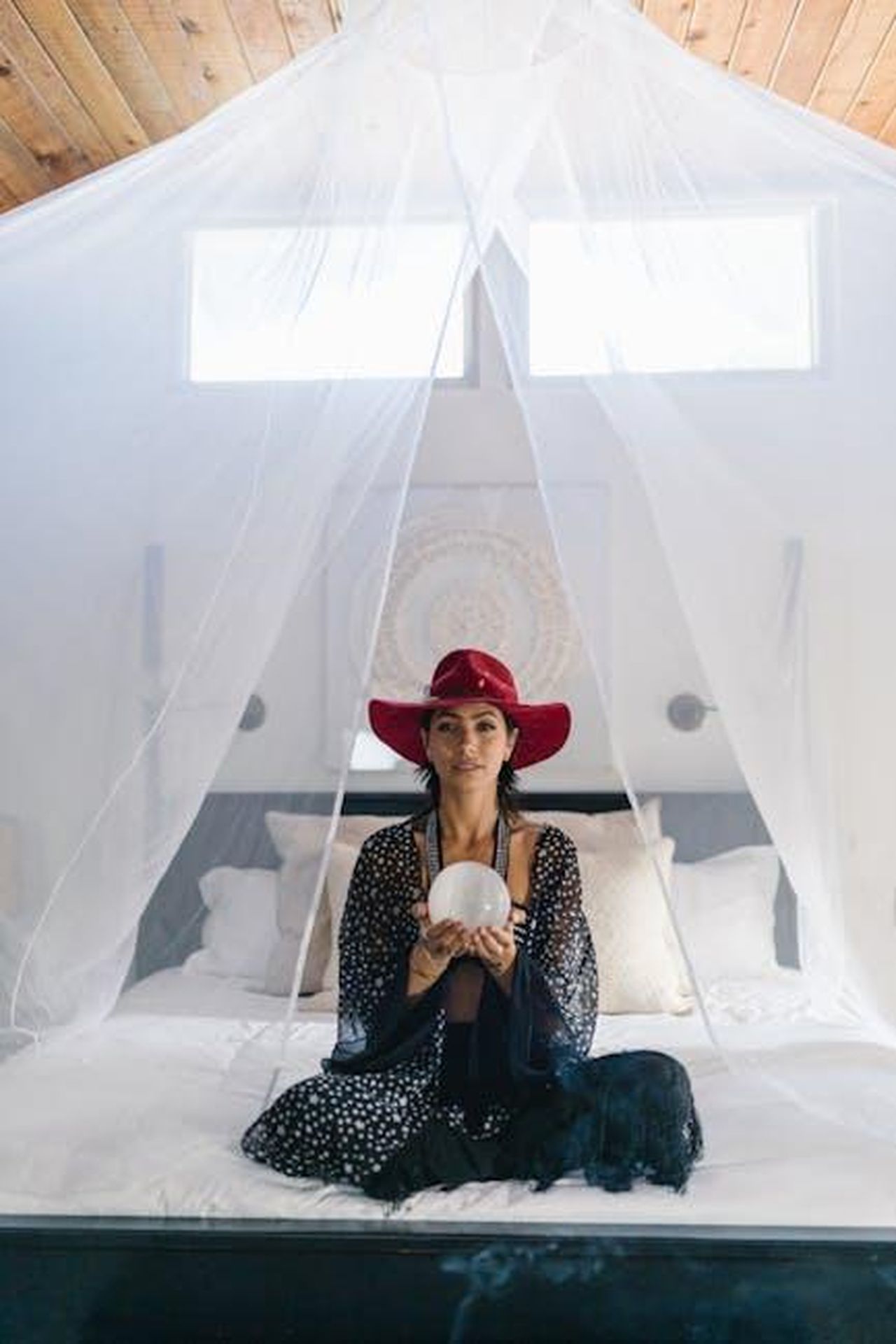 Oroscopo_degli_ultimi_quattro_segni_nIHPA6Y4B6 - Confidenze24 Source: RDNE Stock project - pexels - Woman in a peaceful indoor setting meditating with crystal ball, wearing a red hat and patterned dress.