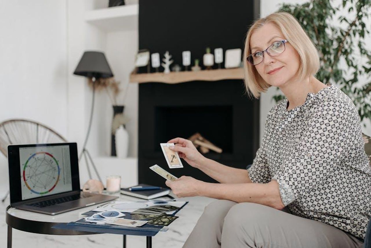 Oroscopo_di_gioved_20_febbraio_pagelle_da_Sagittario_a_Pesci_EjwNRsmfQo - Confidenze24 Source: Pavel Danilyuk - pexels - Woman with tarot cards using laptop for astrology reading in cozy living room.
