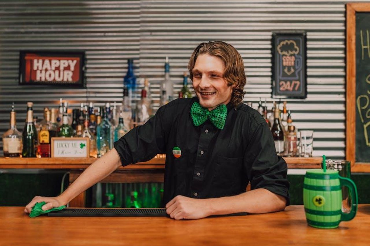 Oroscopo_i_segni_fortunati_del_22_febbraio_CqnmcDj7PR - Confidenze24 Source: RDNE Stock project - pexels - Smiling bartender dressed in green serving drinks during St. Patrick's Day in a pub.