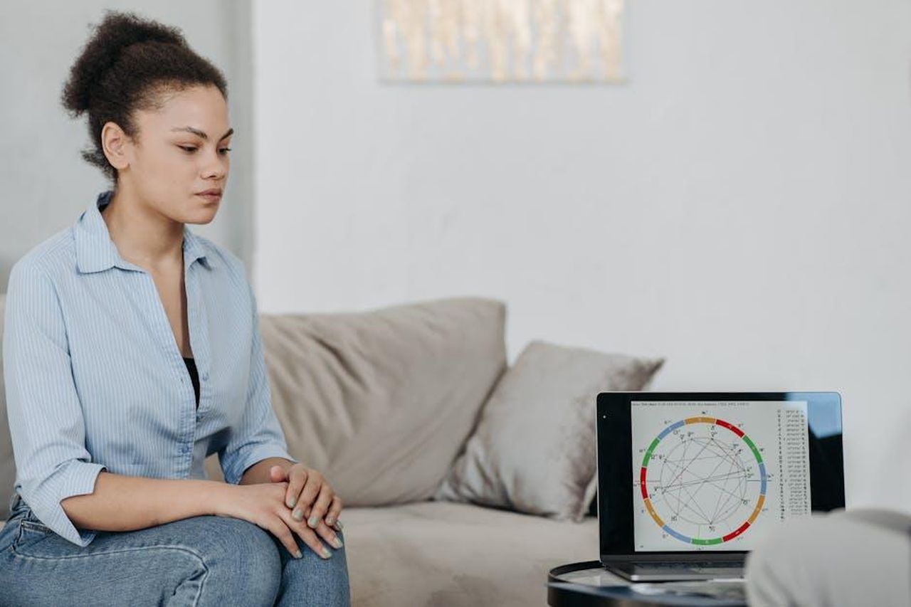 Oroscopo_segni_fortunati_del_22_febbraio_h6TTOMy1IQ - Confidenze24 Source: Pavel Danilyuk - pexels - Young woman sitting in a living room analyzing an astrology chart on a laptop, reflecting concentration.
