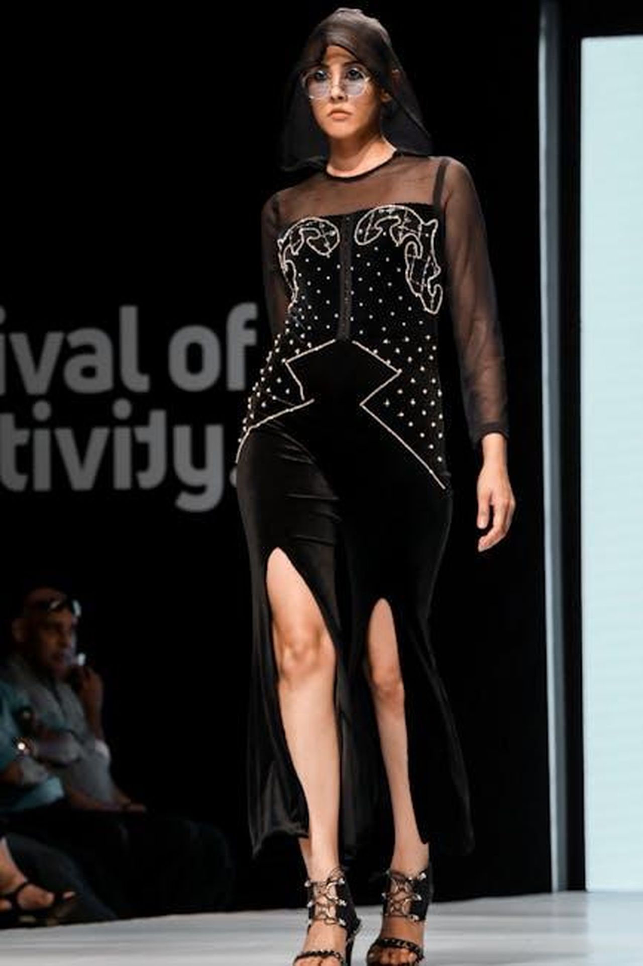 Passerella_per_le_dame_OekTbt7xJ5 - Confidenze24 Source: sk - pexels - Fashion model showcasing a stylish black dress at a runway event.