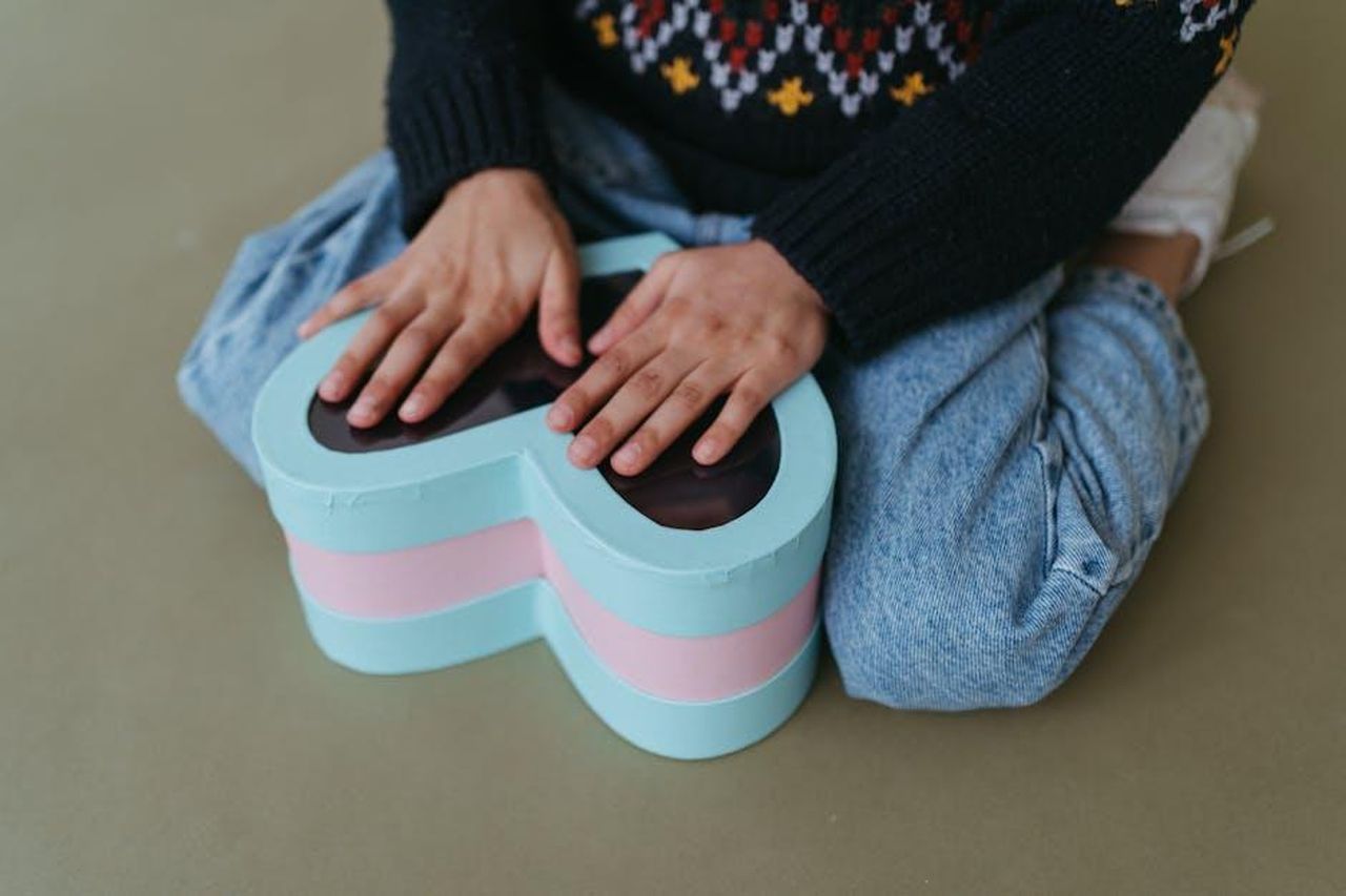 Pesci_Sensibilit_e_introspezione_BzgVZaZzrY - Confidenze24 Source: Anastasia Shuraeva - pexels - Close-up of a child's hands holding a heart-shaped box, evoking warmth and care.