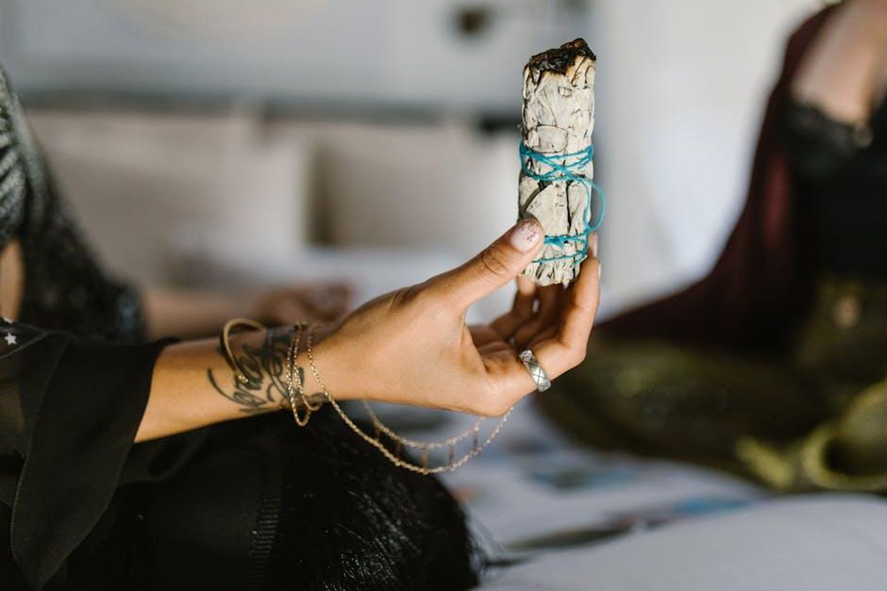 Pesci_approccio_nuovo_in_amore_HlRMeHEvub - Confidenze24 Source: RDNE Stock project - pexels - A person holding a sage bundle tied with blue string, often used in spiritual cleansing rituals.