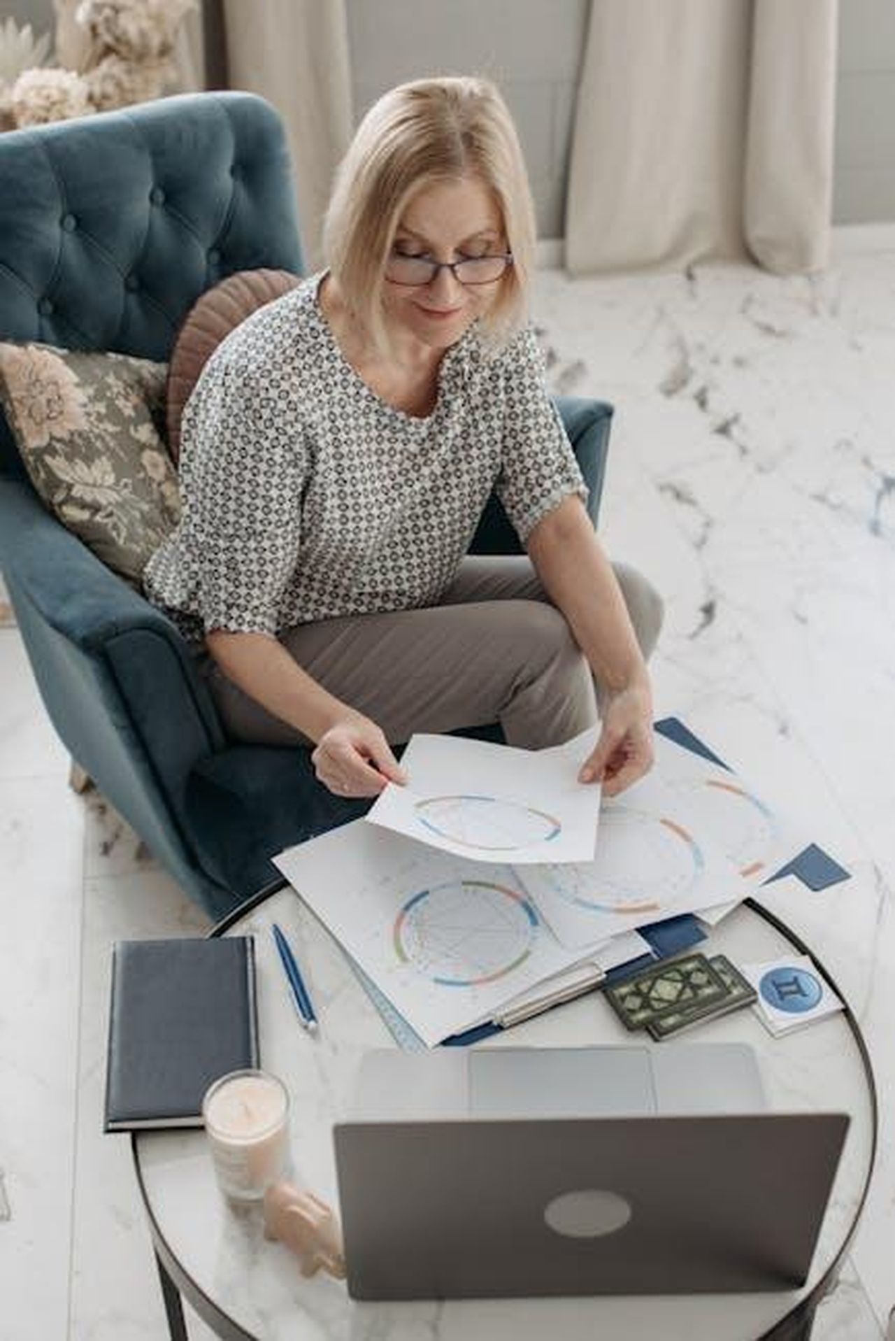 Pesci_sfide_e_pazienza_1q4BRzdWmB - Confidenze24 Source: Pavel Danilyuk - pexels - Elderly woman examines astrology charts on a laptop in a cozy living room setting.