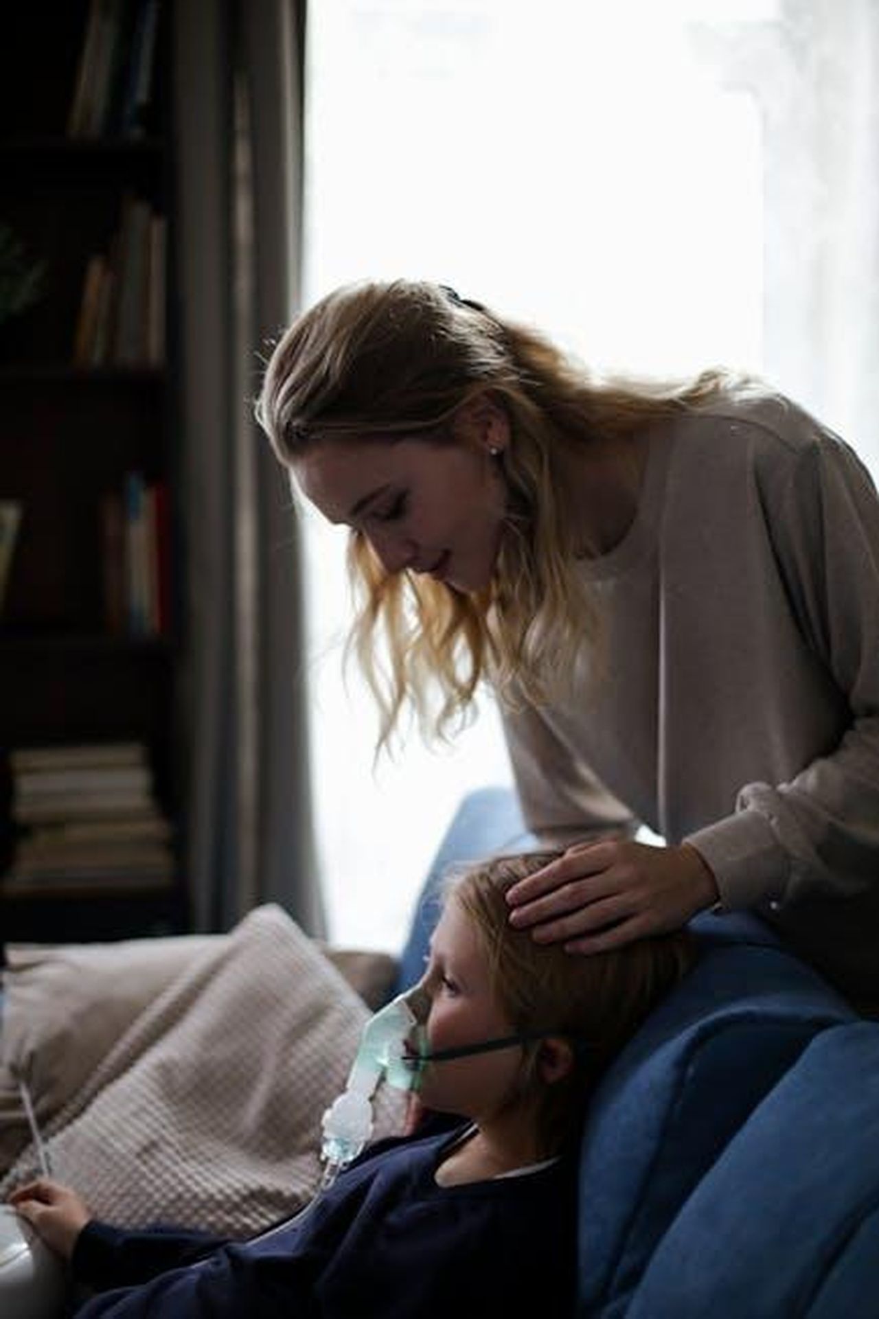 Possibili_cause_della_morte_Hf3DvTTWxn - Confidenze24 Source: cottonbro studio - pexels - A mother tends to her sick child using an inhaler, emphasizing care and health.