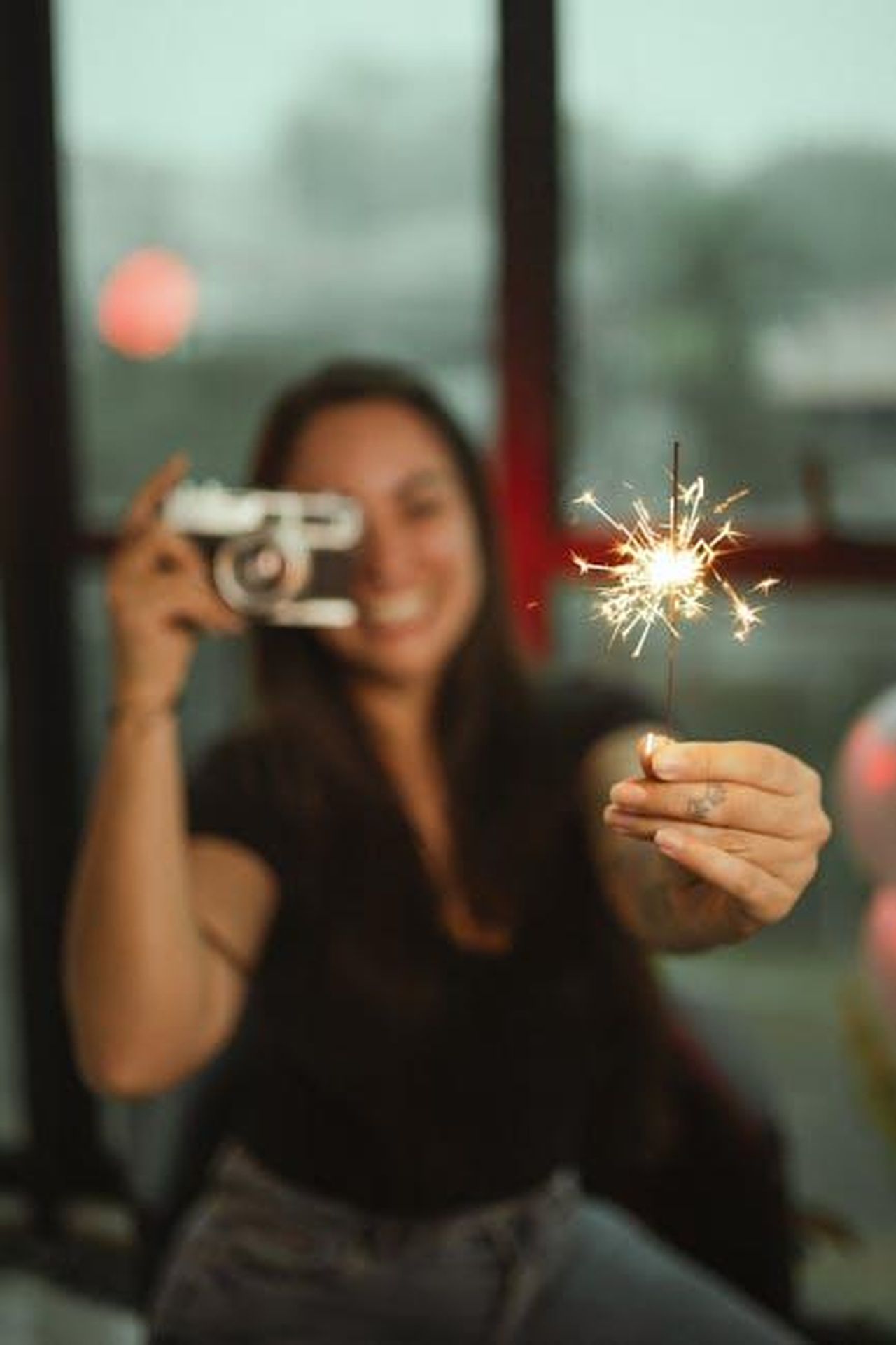 Possibilit_di_televoto_flash_per_Zeudi_ZKP8n38SdR - Confidenze24 Source: Marcelo Chagas - pexels - Joyful woman holding sparkler indoors, capturing festive moments with a camera.