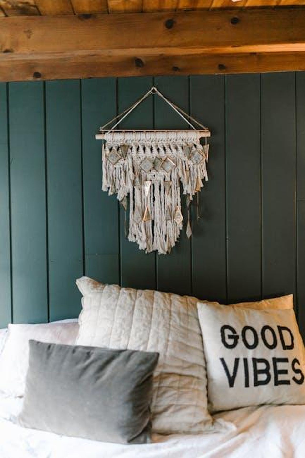 Previsioni_astrologiche_del_17_febbraio_con_posizioni_Capricorno_in_vetta_alla_classifica_giornaliera_VfXnAL2h3f - Confidenze24 Source: RDNE Stock project - pexels - Cozy bedroom featuring a stylish macramé wall hanging and a pillow with 'Good Vibes' text.