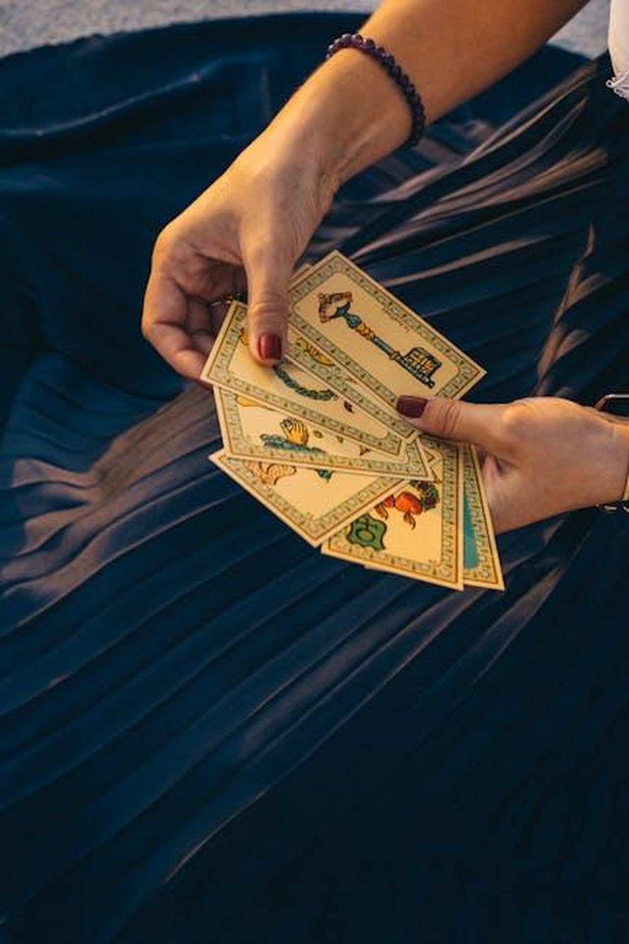 Previsioni_astrologiche_per_il_giorno_21_febbraio_pagelle_da_Sagittario_a_Pesci_tbm9VaBSzE - Confidenze24 Source: Anna Tarazevich - pexels - A woman holding tarot cards for a spiritual reading, set against a dark fabric backdrop.