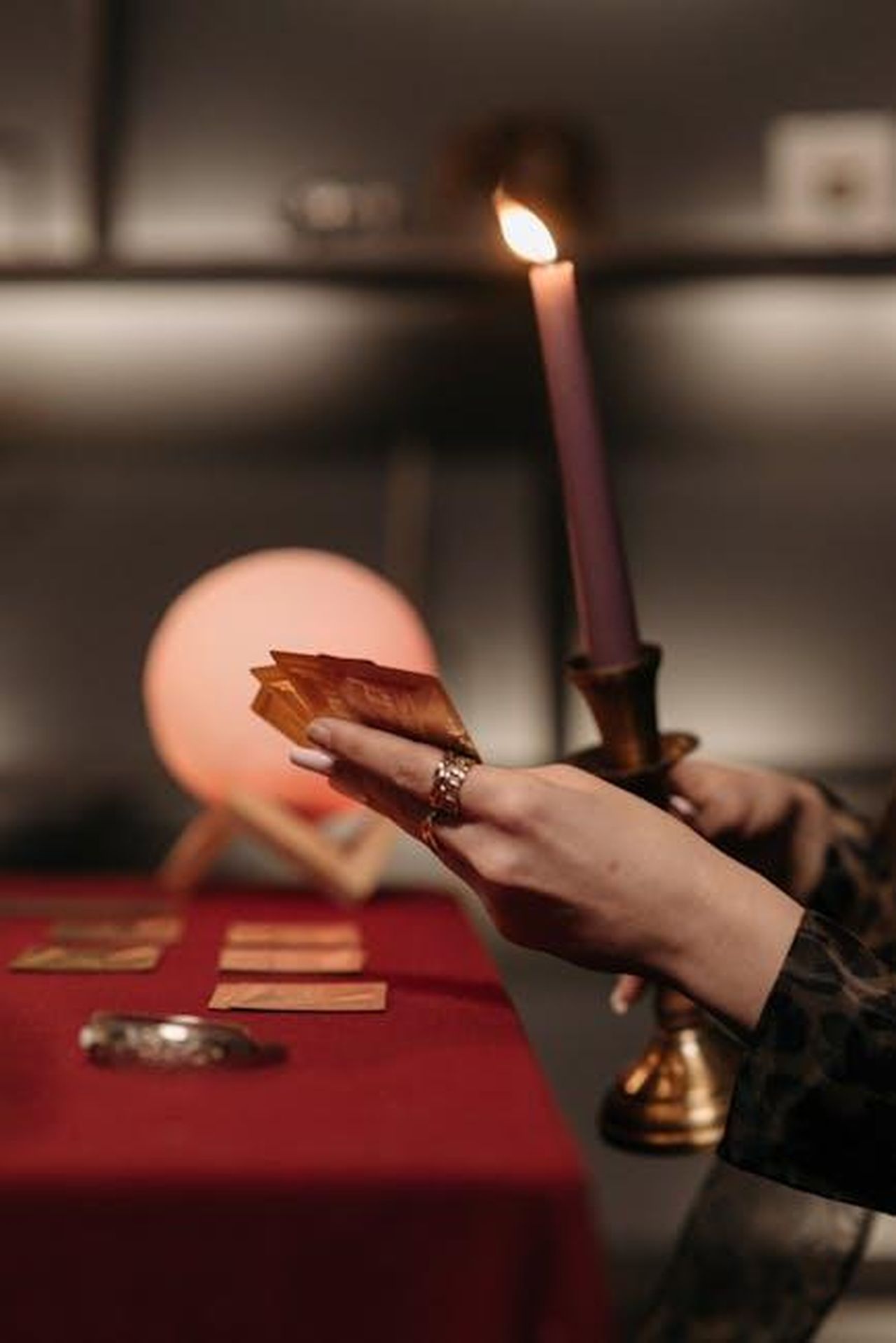 Previsioni_per_gli_Oscar_2025_xB4M2CXejW - Confidenze24 Source: Pavel Danilyuk - pexels - Close-up of hands holding tarot cards by candlelight on a fortune-telling table.